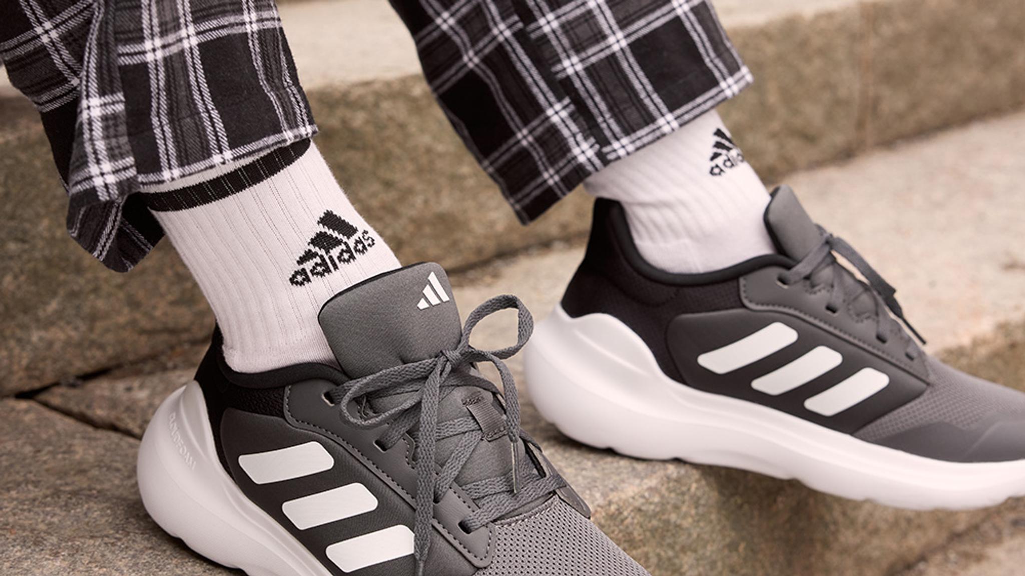 a kid is wearing a pair of adidas shoes and socks .
