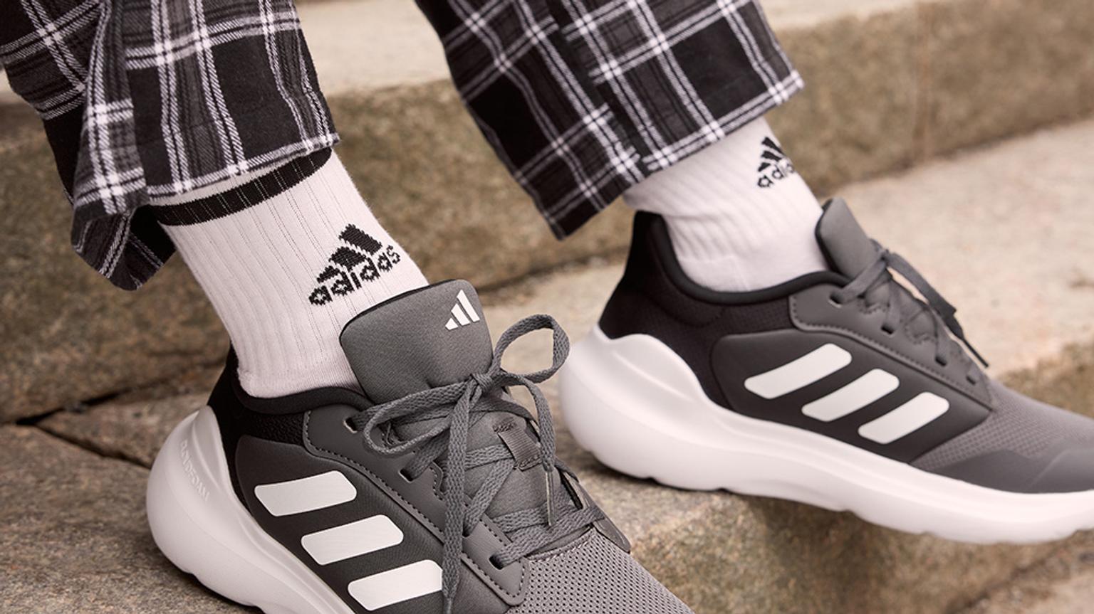 a kid is wearing a pair of adidas shoes and socks .