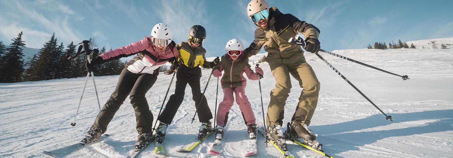 En familj står i skidbacken