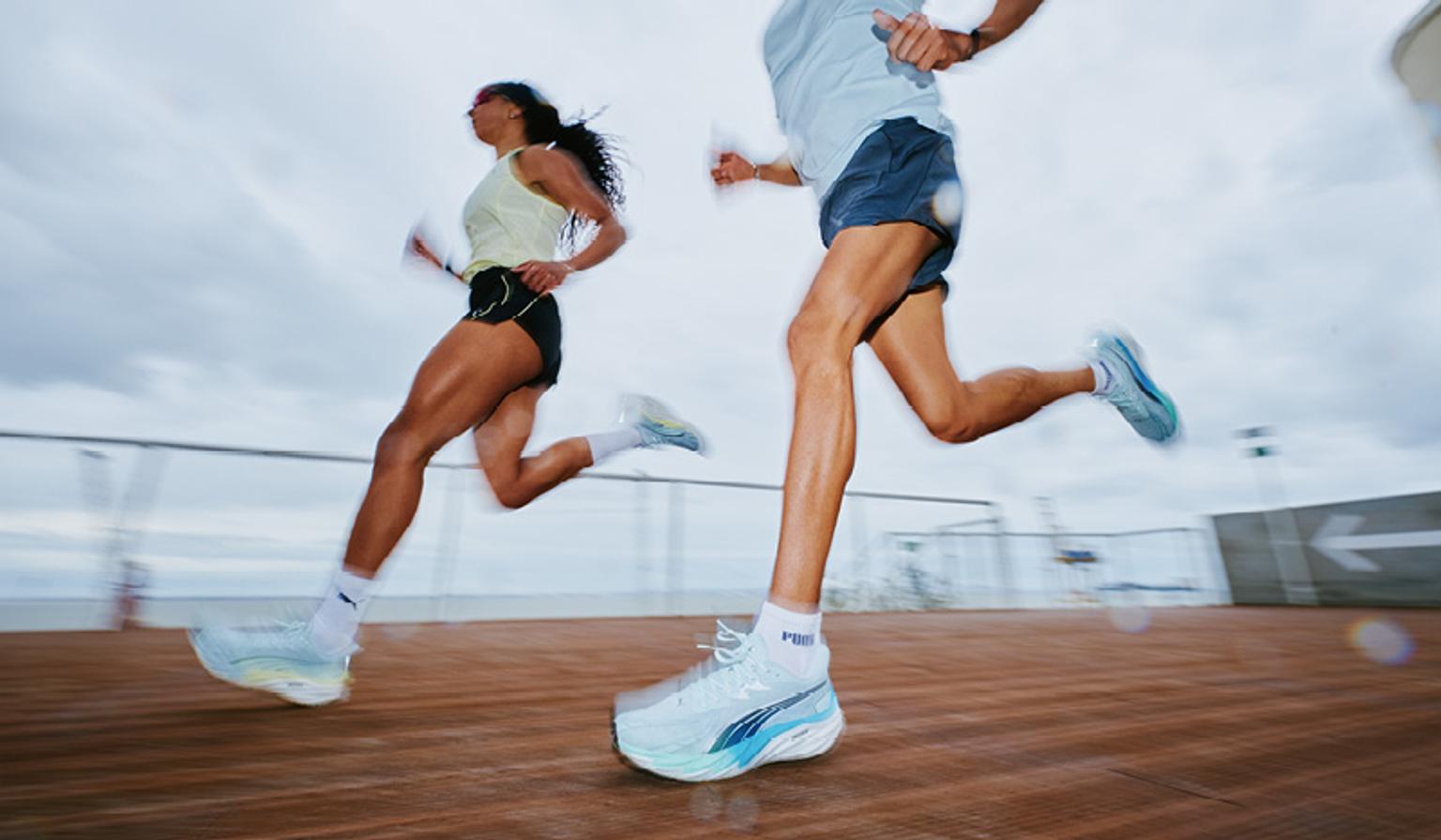 a man and a woman are running on a wooden deck .