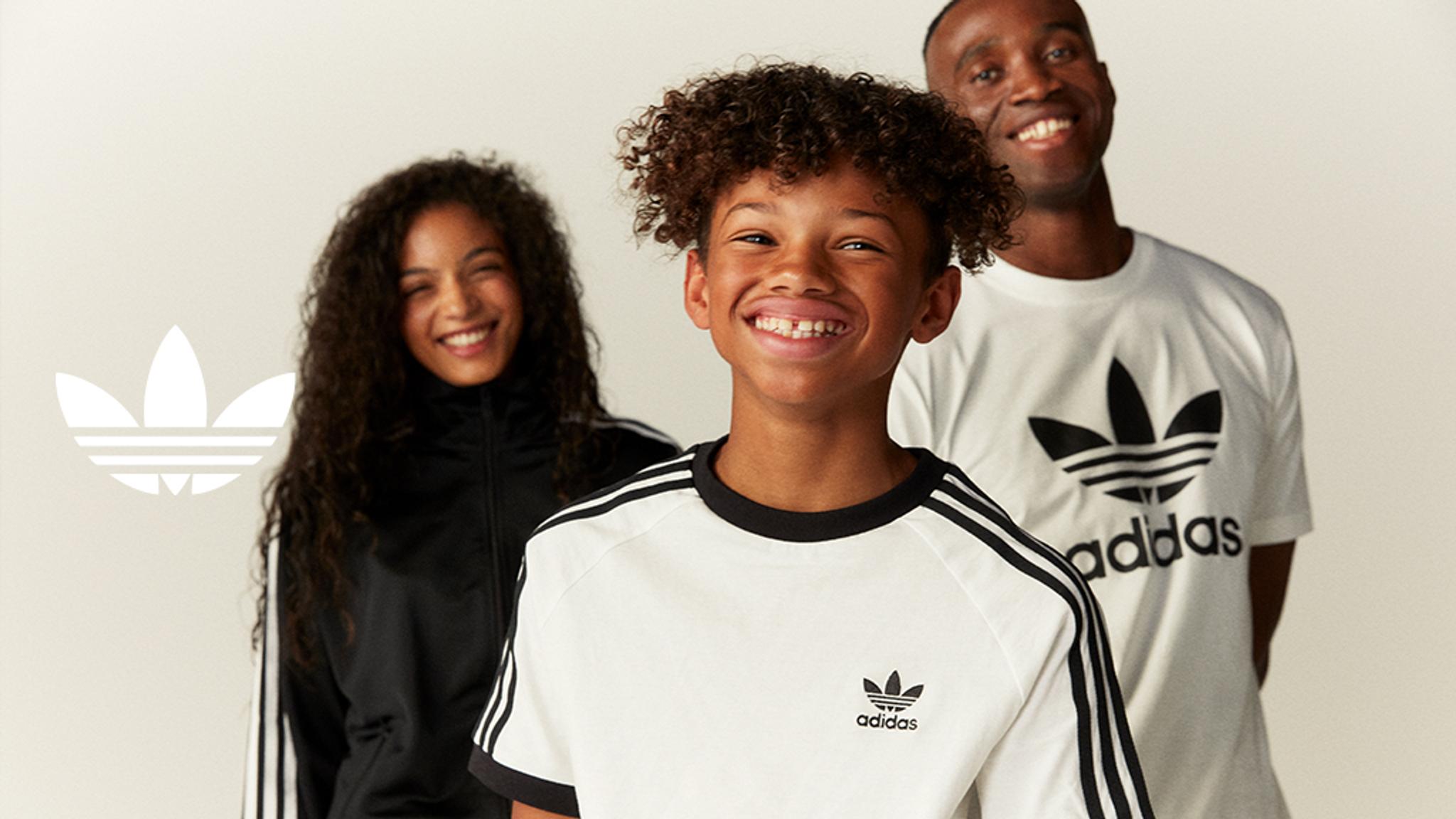 a man , a woman and a boy are standing next to each other and smiling .