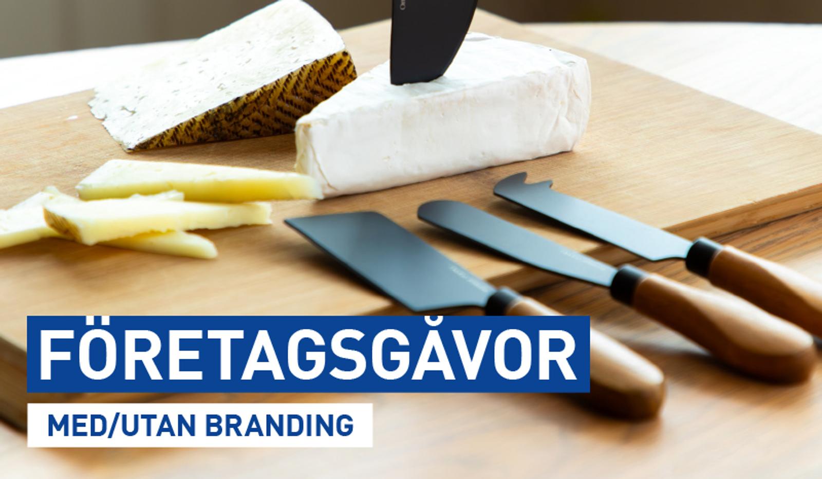 a cutting board with a piece of cheese and knives on it .