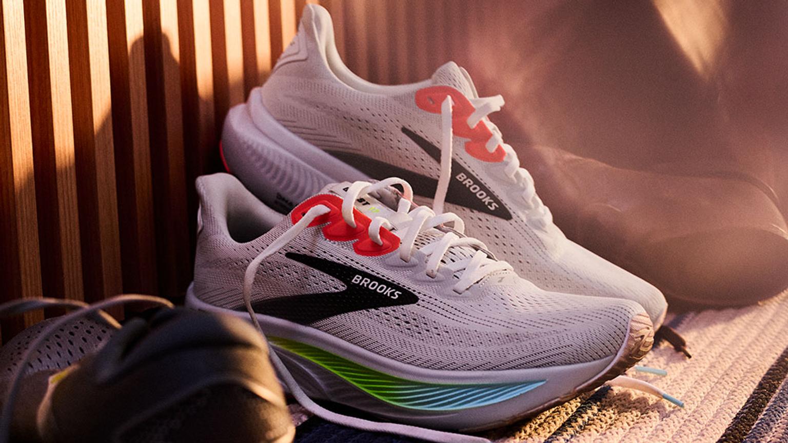 a pair of brooks running shoes are sitting on top of each other on a table .