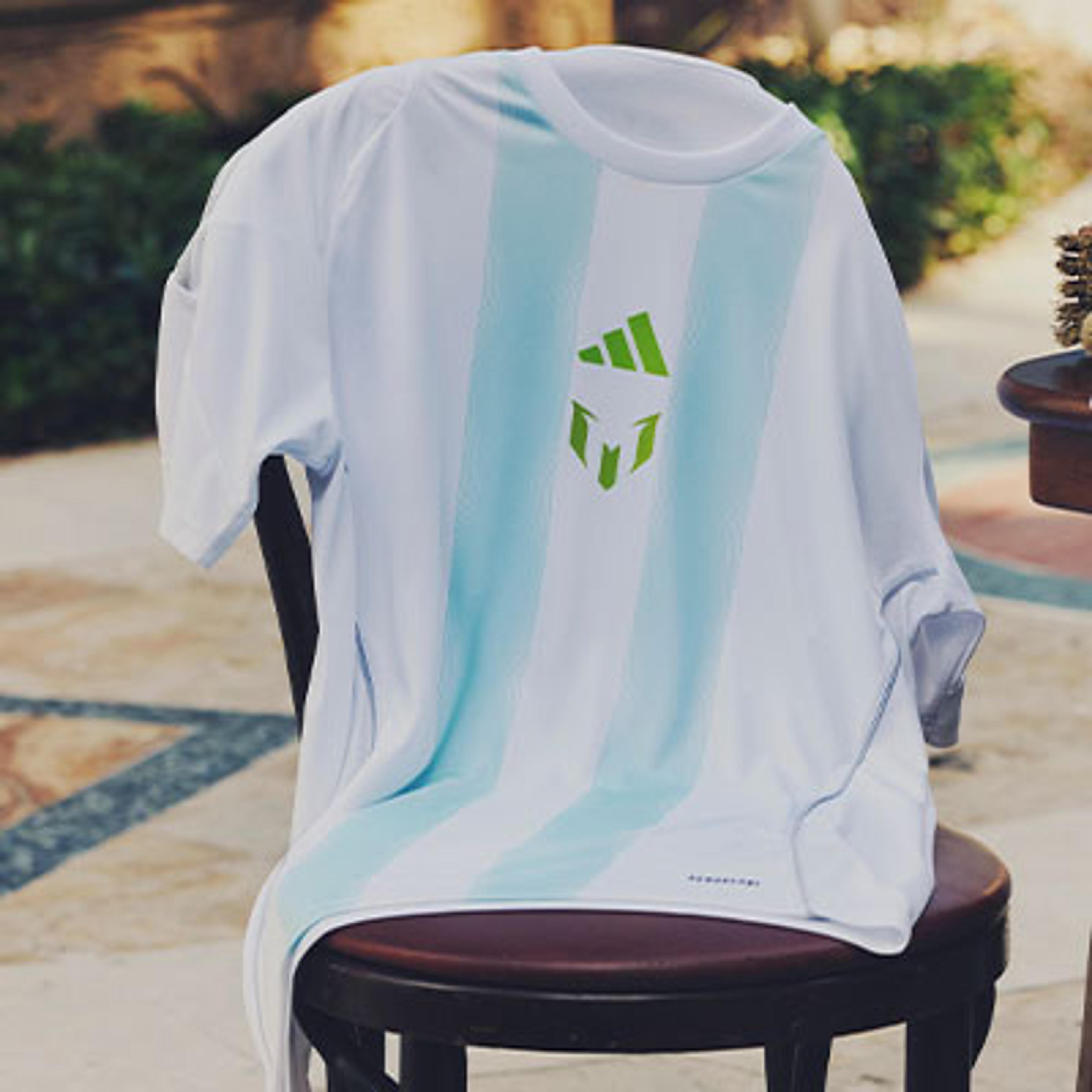 a white t-shirt with a green logo on the back is sitting on a chair .