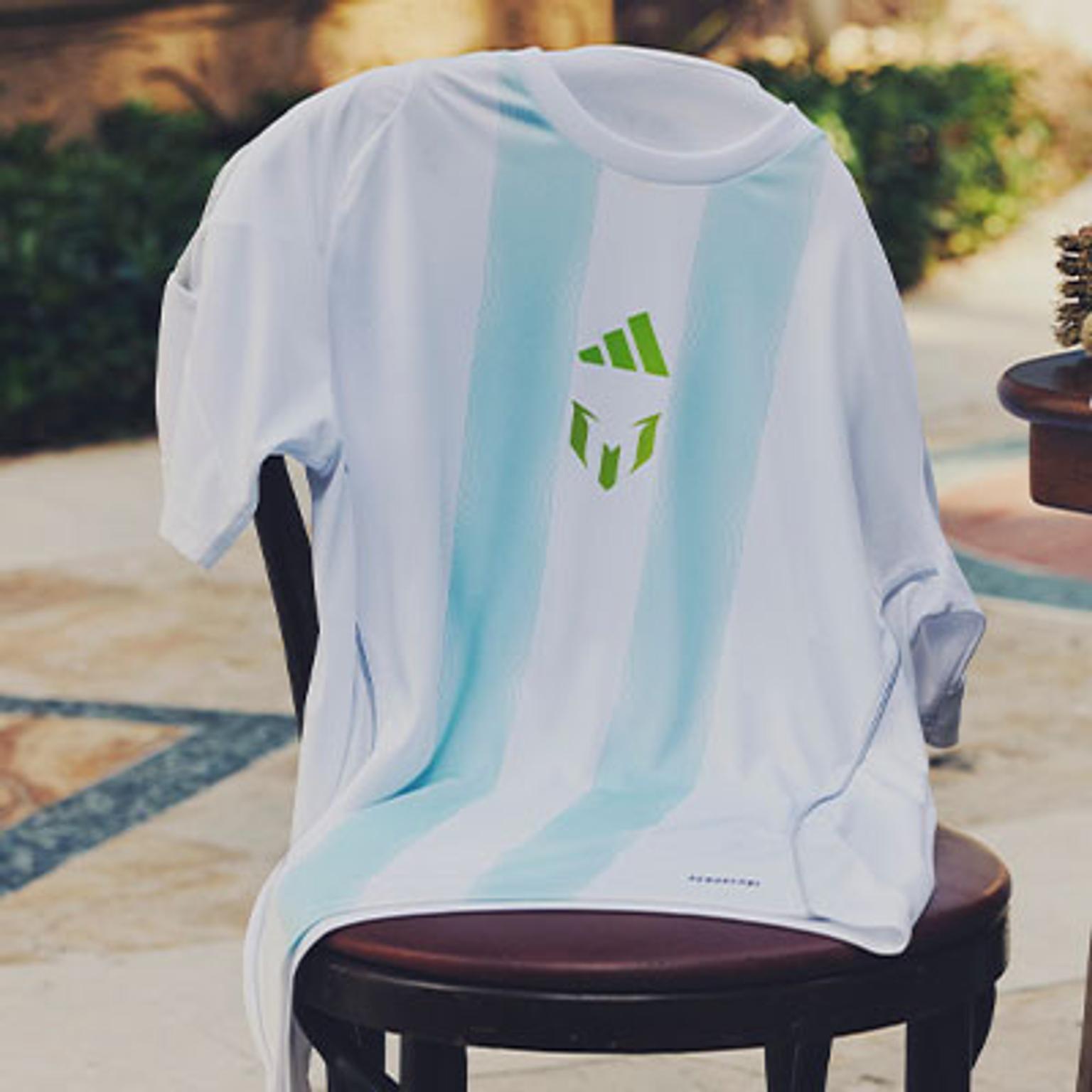 a white t-shirt with a green logo on the back is sitting on a chair .
