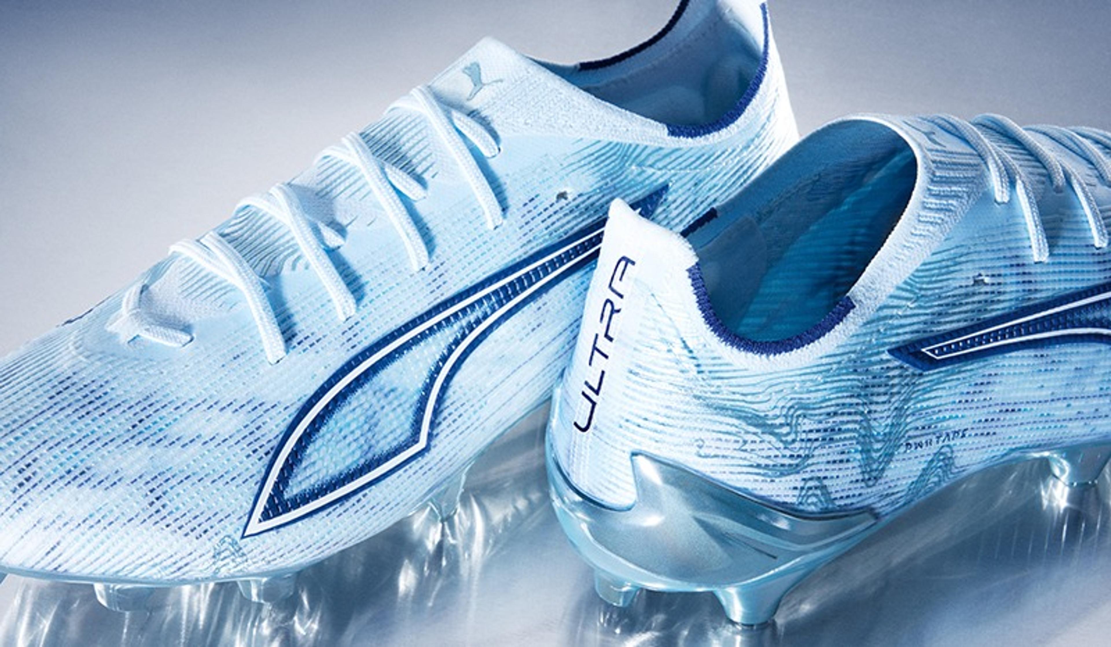 A pair of light blue and white Puma Ultra soccer cleats with a wavy design.