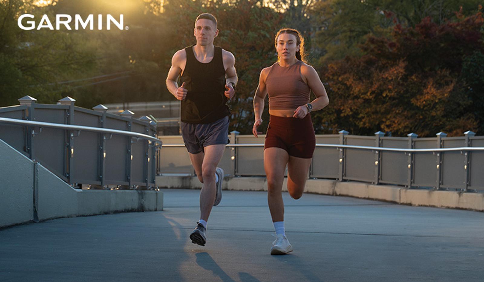 Garmin logo over a man and a woman running on a bridge in golden light.