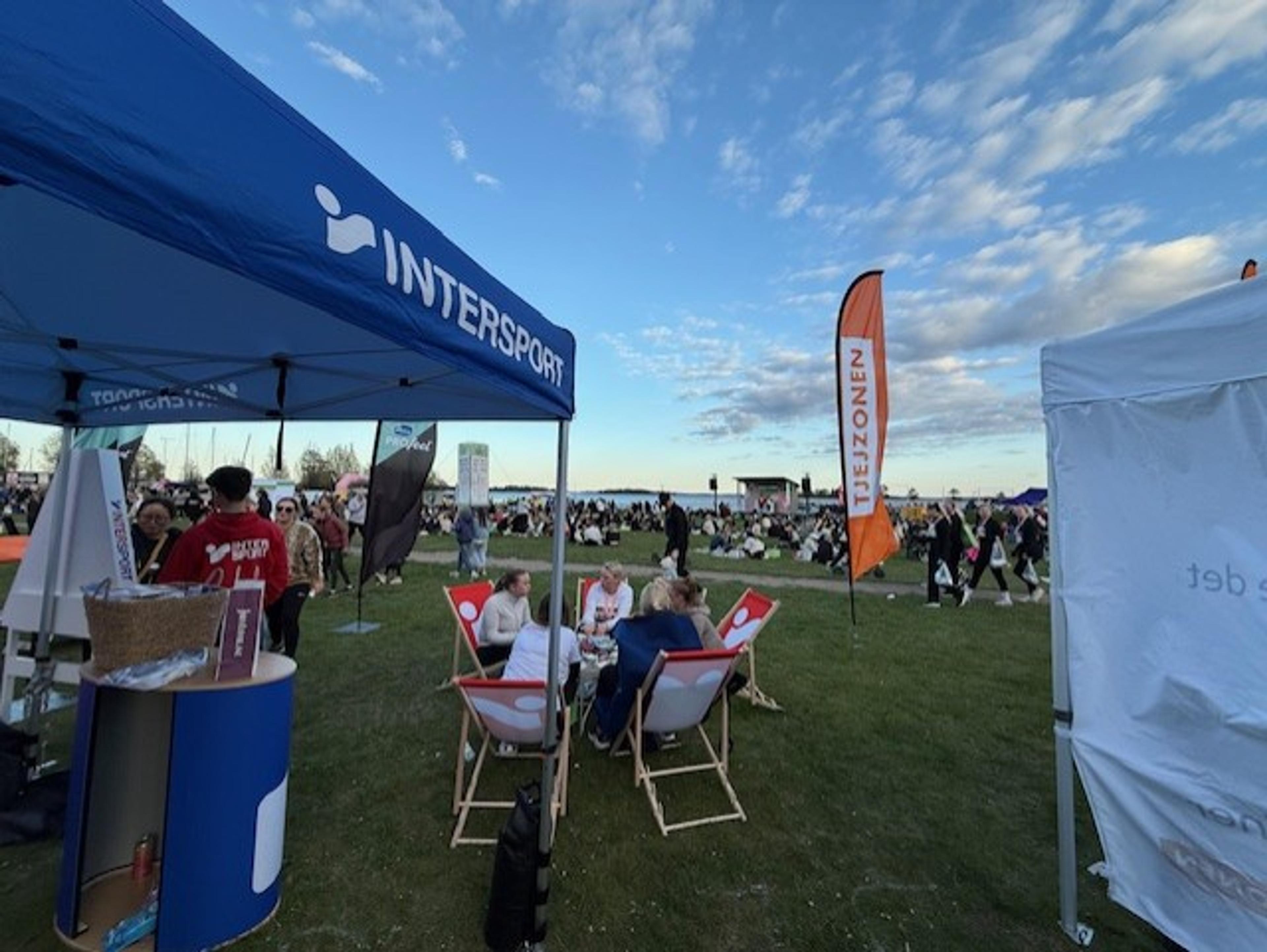 a group of people are sitting in lawn chairs under a tent .