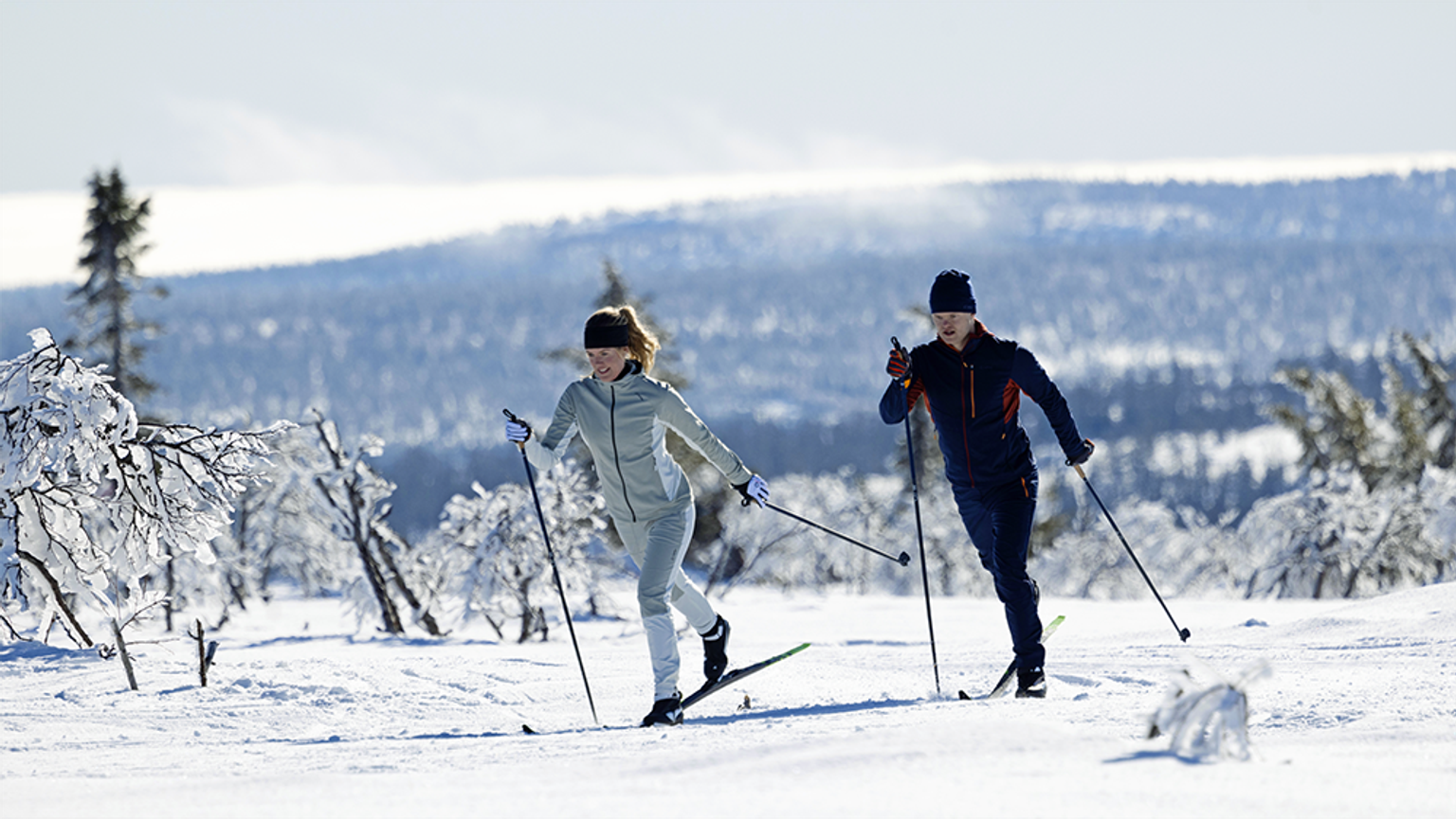 a man and a woman cross country skiing in the snow