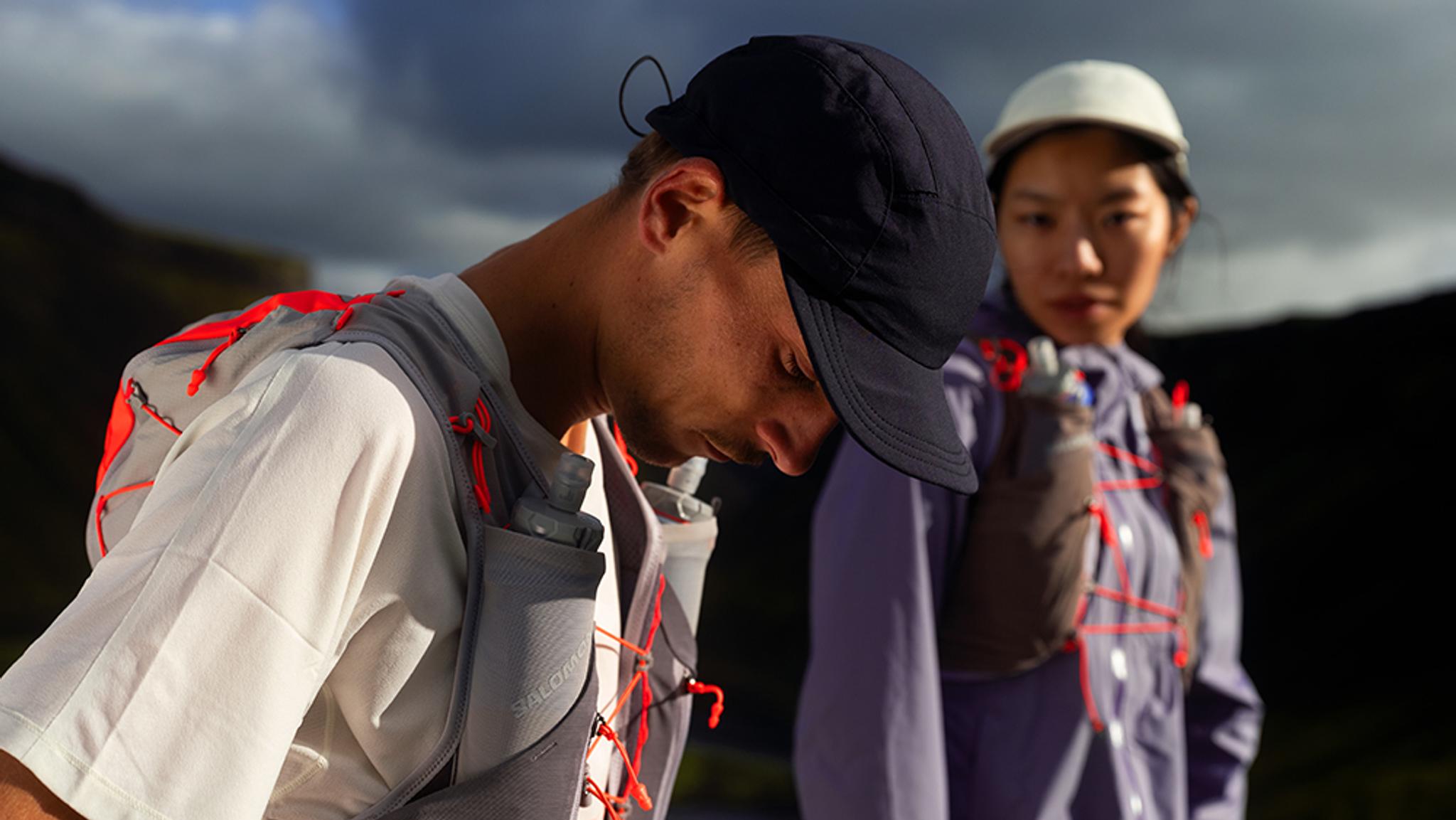 a man and a woman are standing next to each other in the mountains .