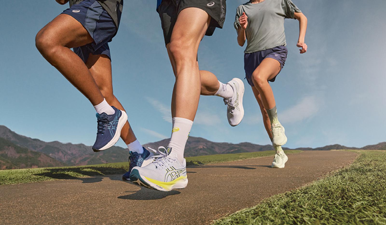 a group of people are running down a road .