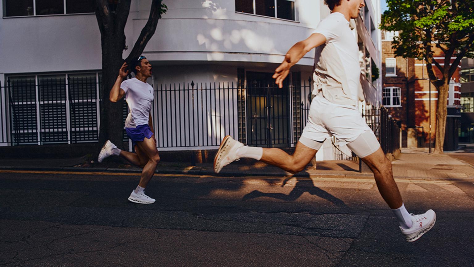 a man and a woman are running down a city street .