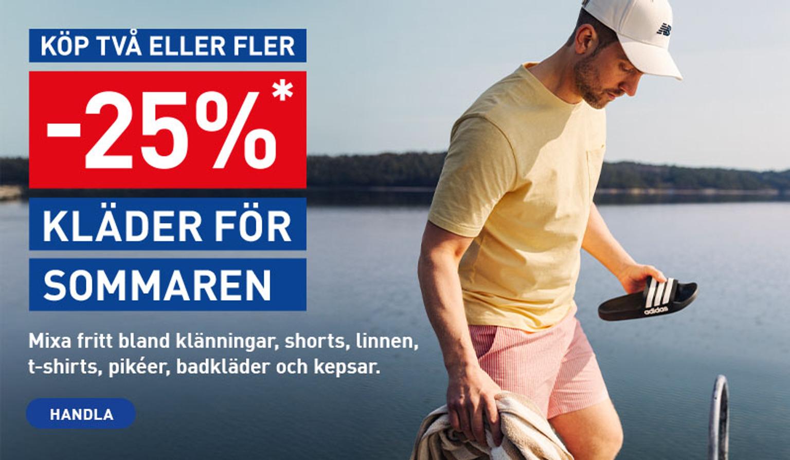 a man wearing a hat and shorts is standing next to a body of water .