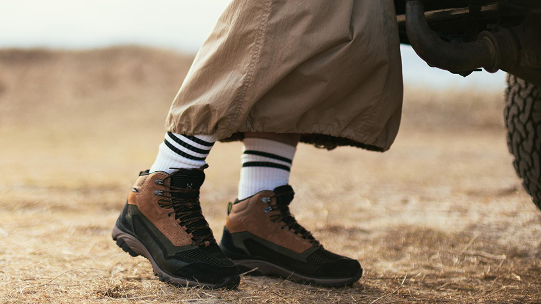 a person wearing a pair of salomon shoes is walking through a puddle of water .