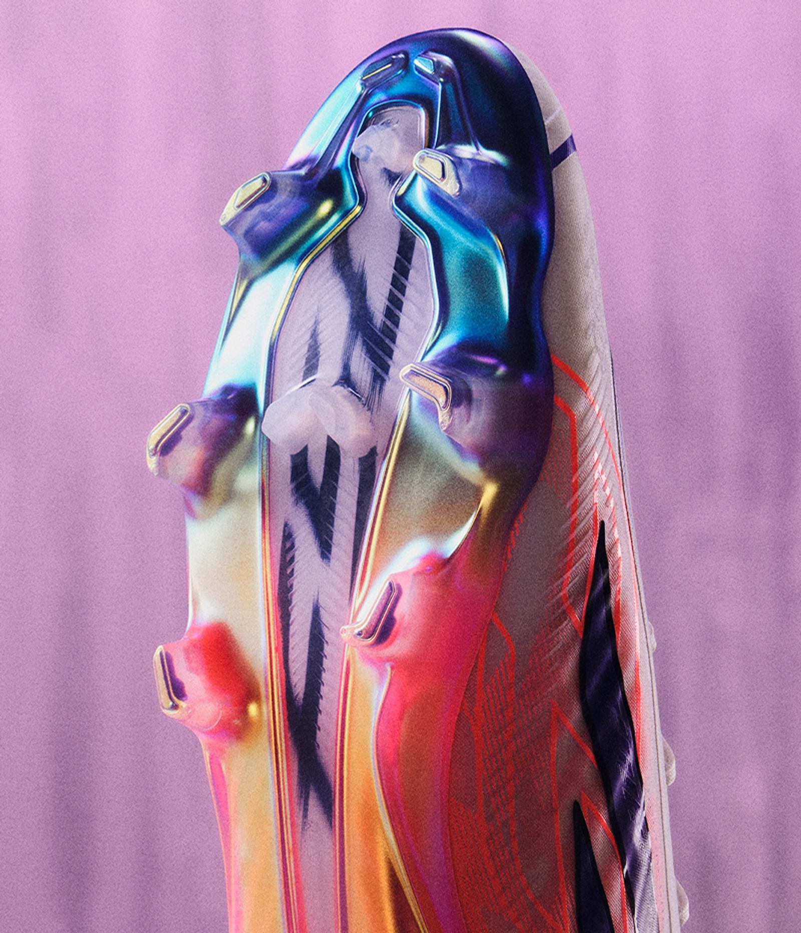 Iridescent football boot sole with colorful studs against a purple background.