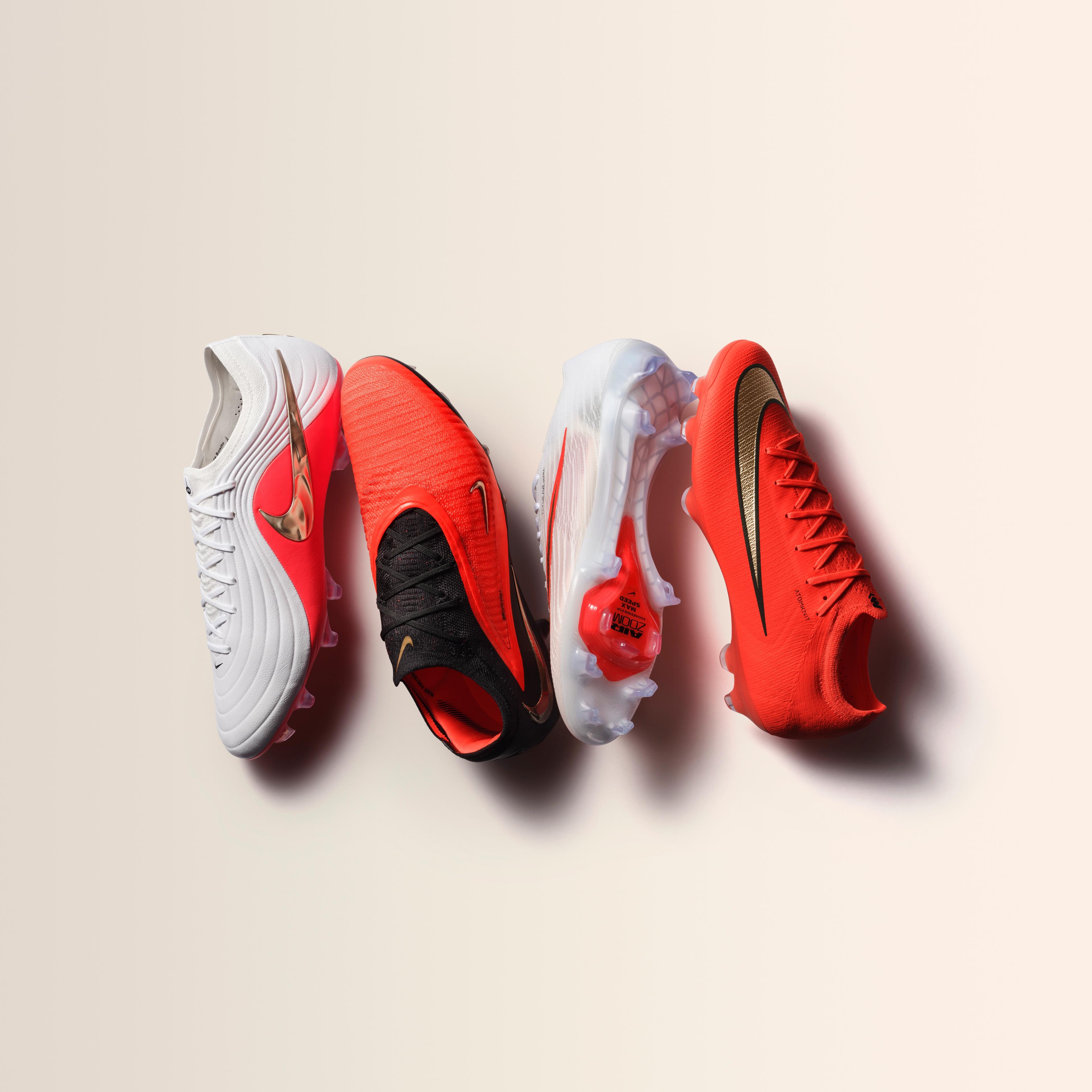 Four Nike football cleats in white, orange, and gold colors.