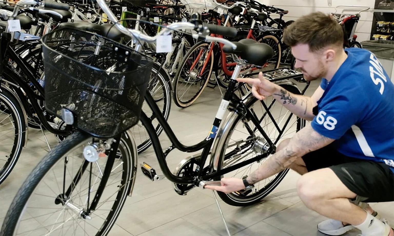 Kille som mäter ramstorlek på cykel