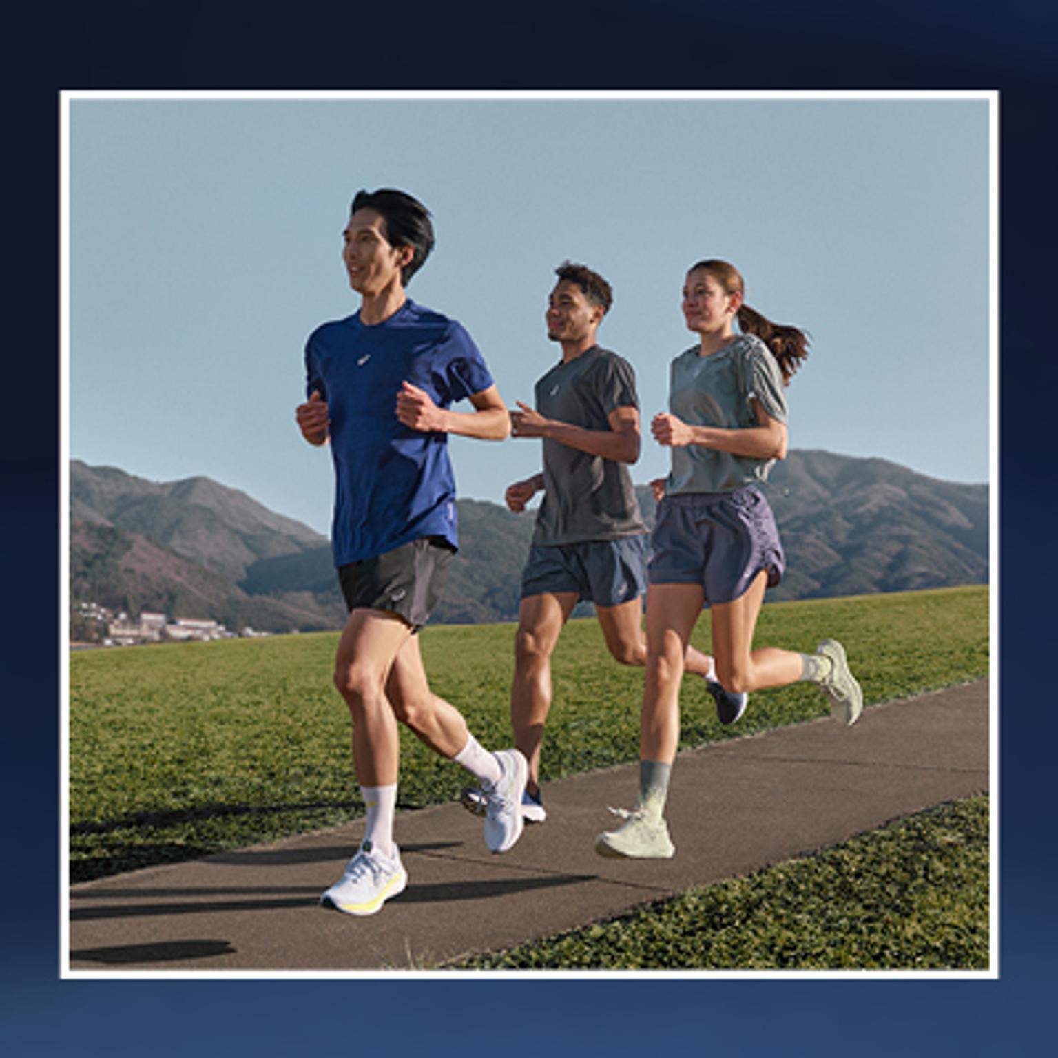 a group of people are running on a sidewalk .