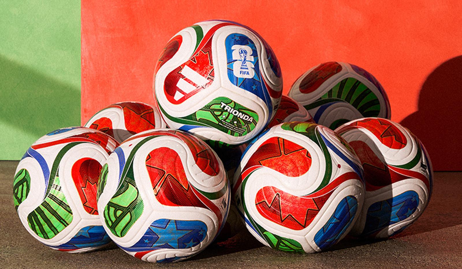 a bunch of soccer balls are stacked on top of each other on the ground .