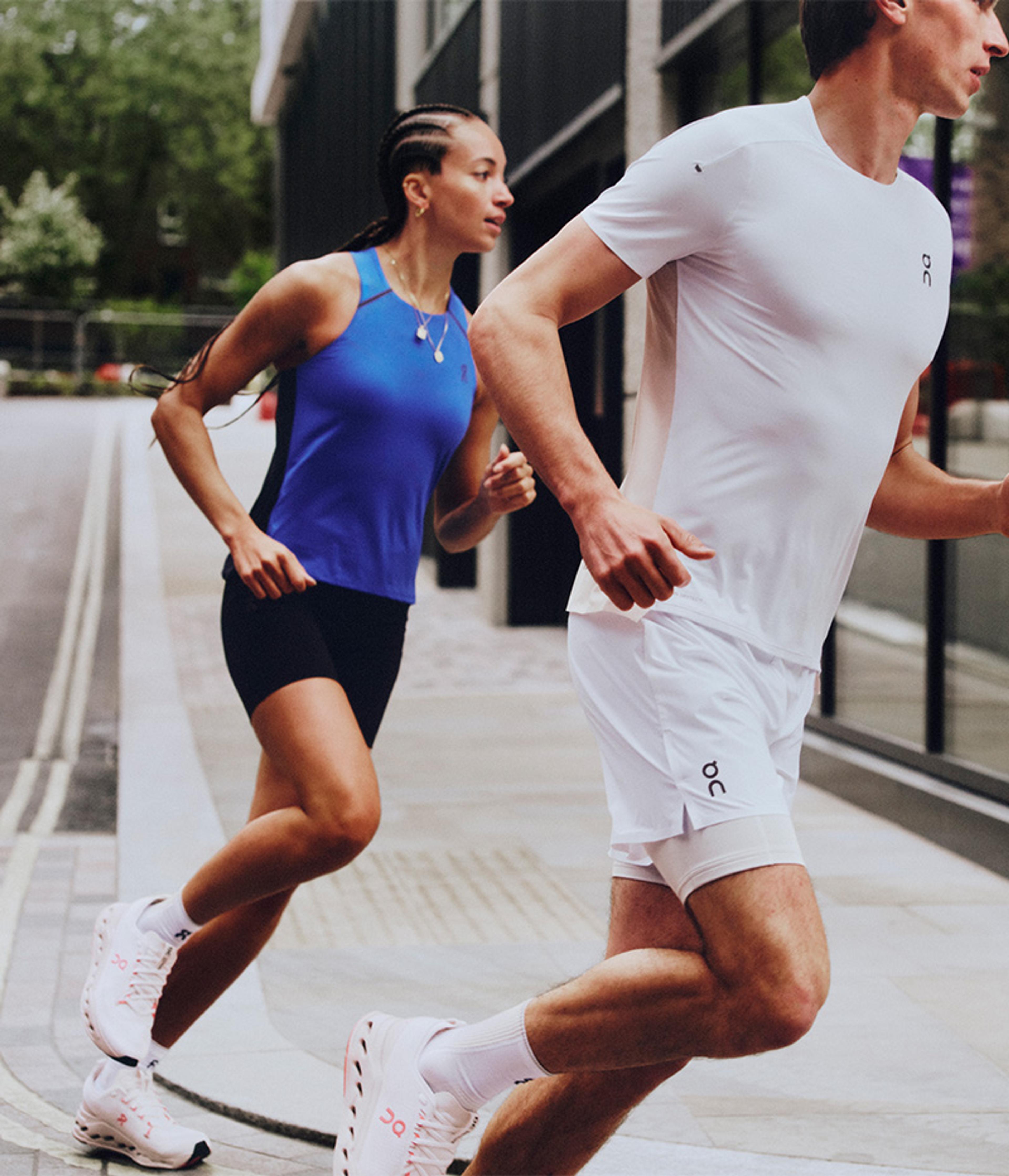 a man and a woman are running down a street .