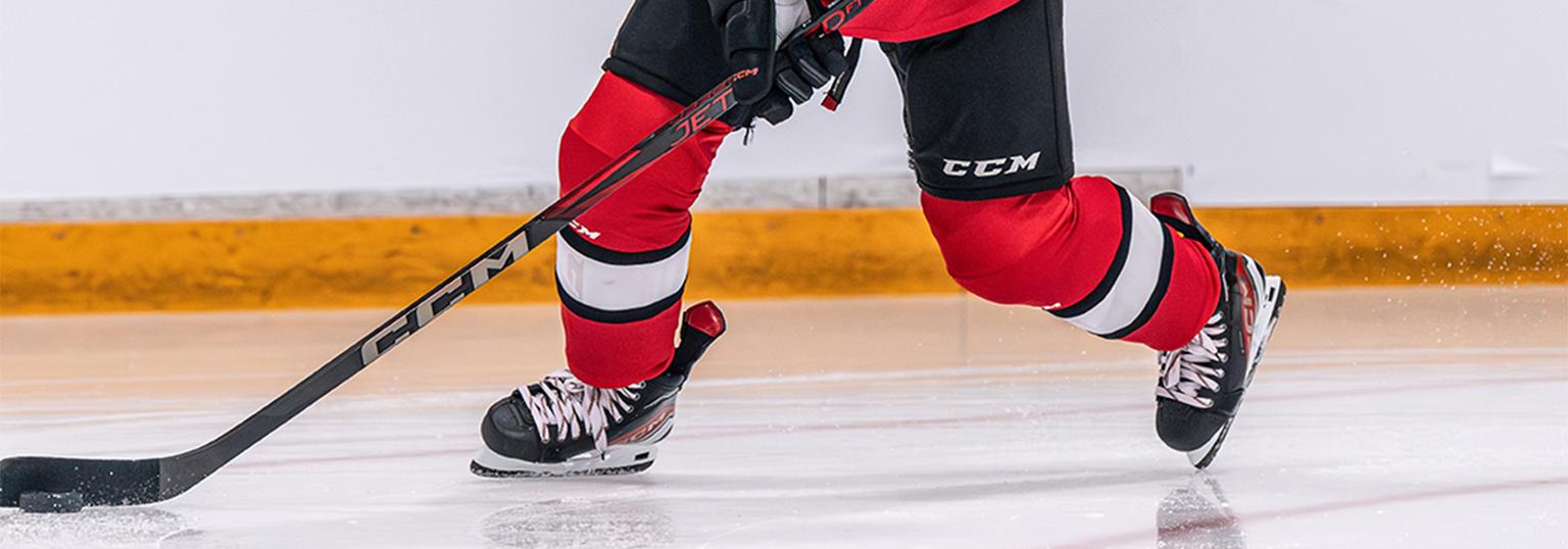 Kille som spelar hockey med en hockeyklubba