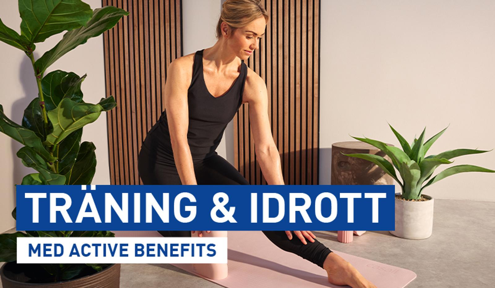 a woman is sitting on a yoga mat stretching her legs .