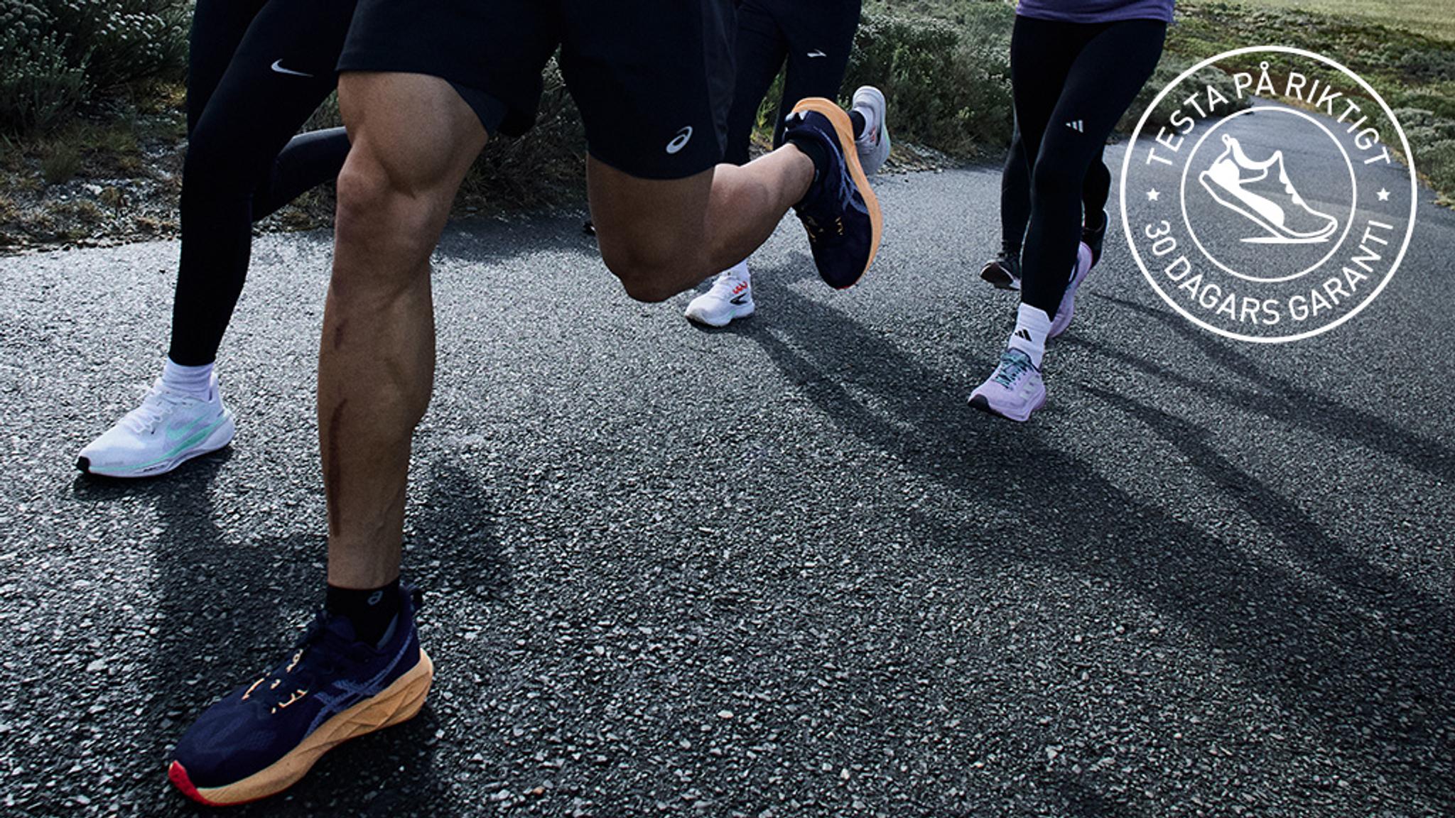 a group of people are running down a road .