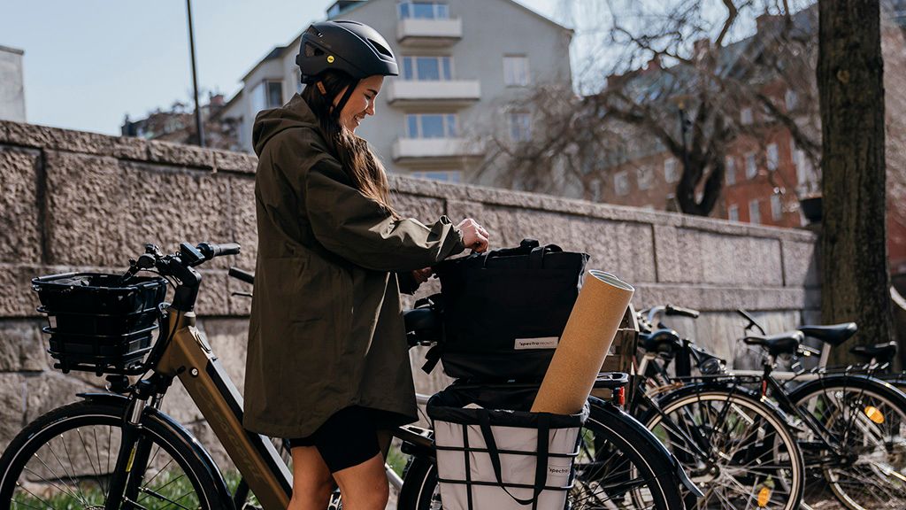 a woman wearing a helmet is standing next to a bicycle .