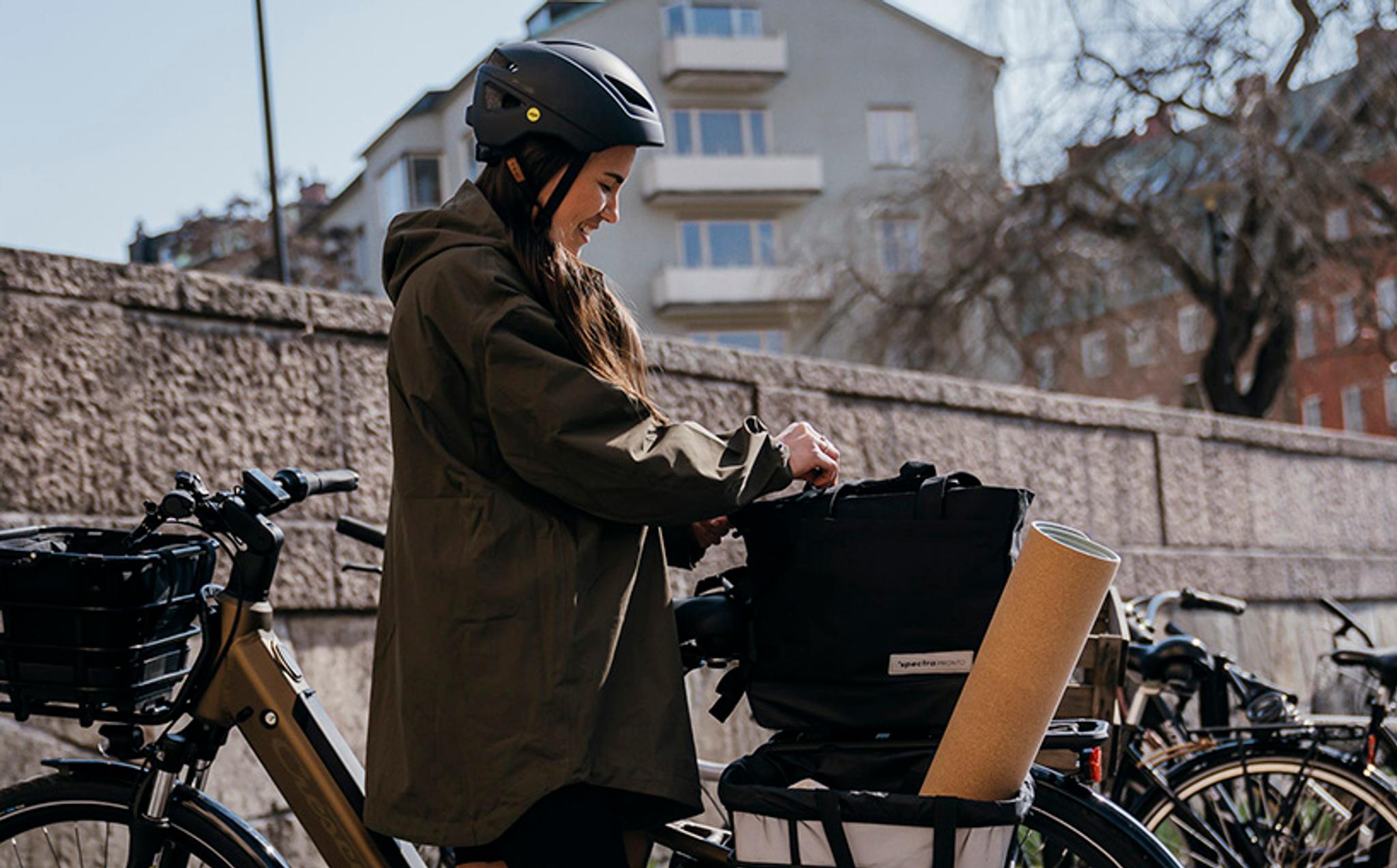 a woman wearing a helmet is standing next to a bicycle .