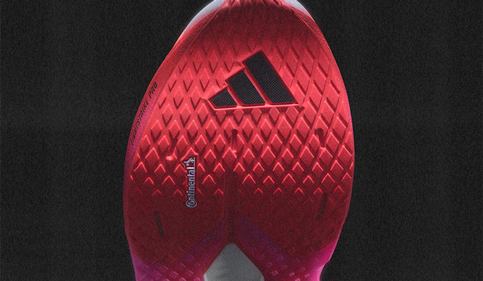 Red Adidas running shoe sole with Continental branding and a diamond tread pattern.