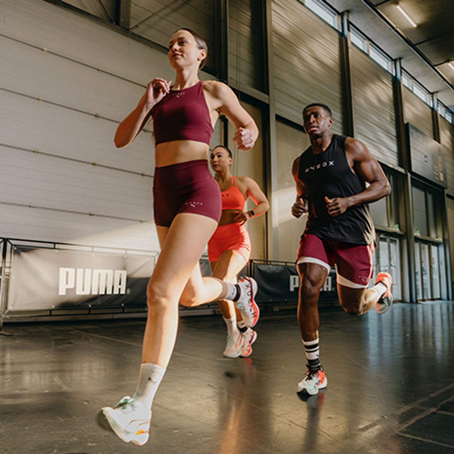 a group of people are running in a gym .