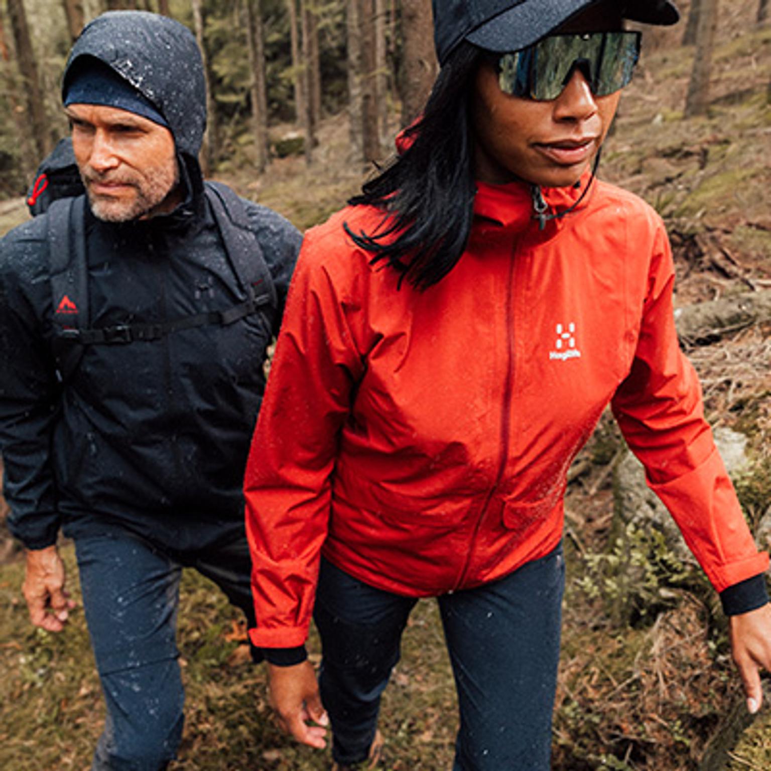 a woman wearing a blue jacket and a black backpack is standing next to a man wearing a blue jacket .