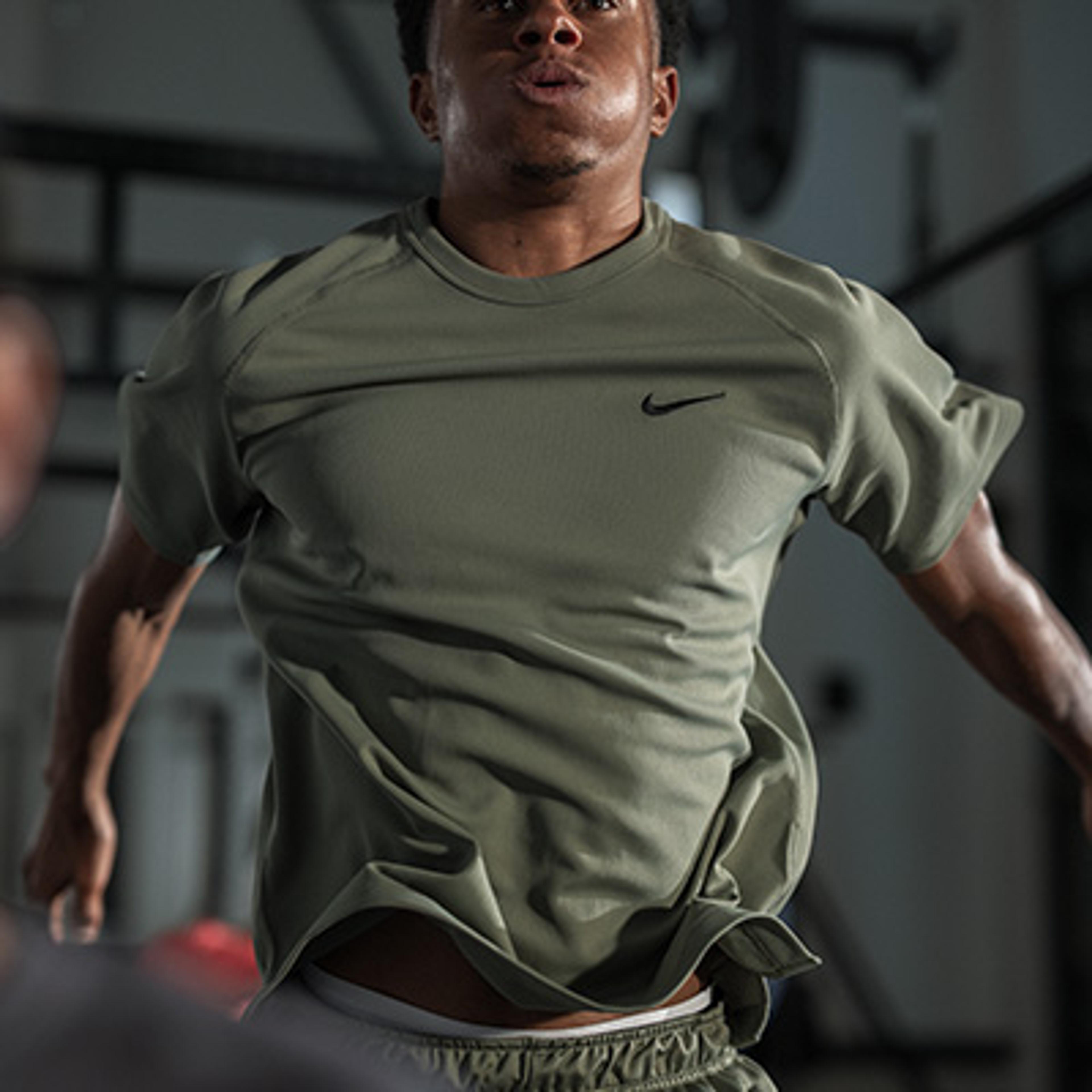 a woman in a purple shirt and purple leggings stretches her arm