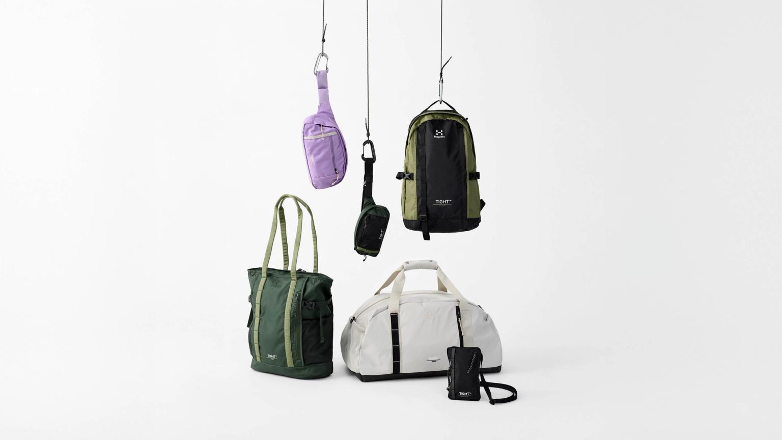 a group of bags hanging from hooks on a white background .