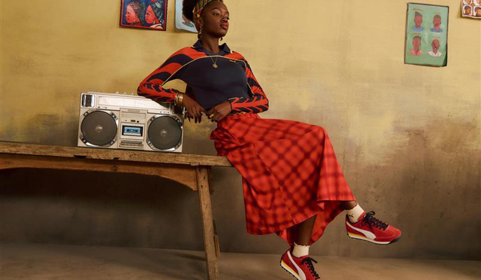 a woman is sitting on a wooden bench next to a boombox .