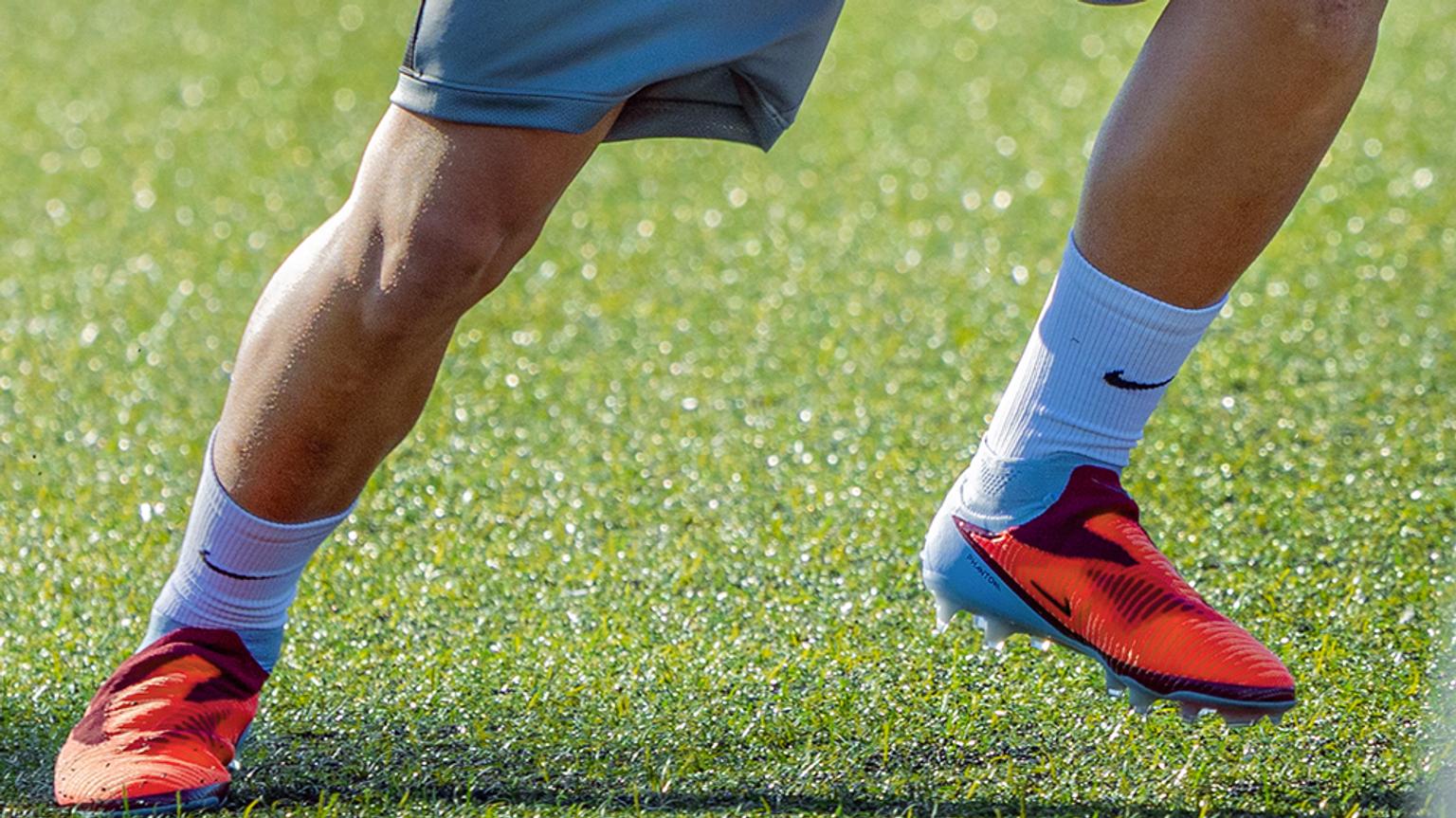a close up of a person wearing soccer cleats on a field .