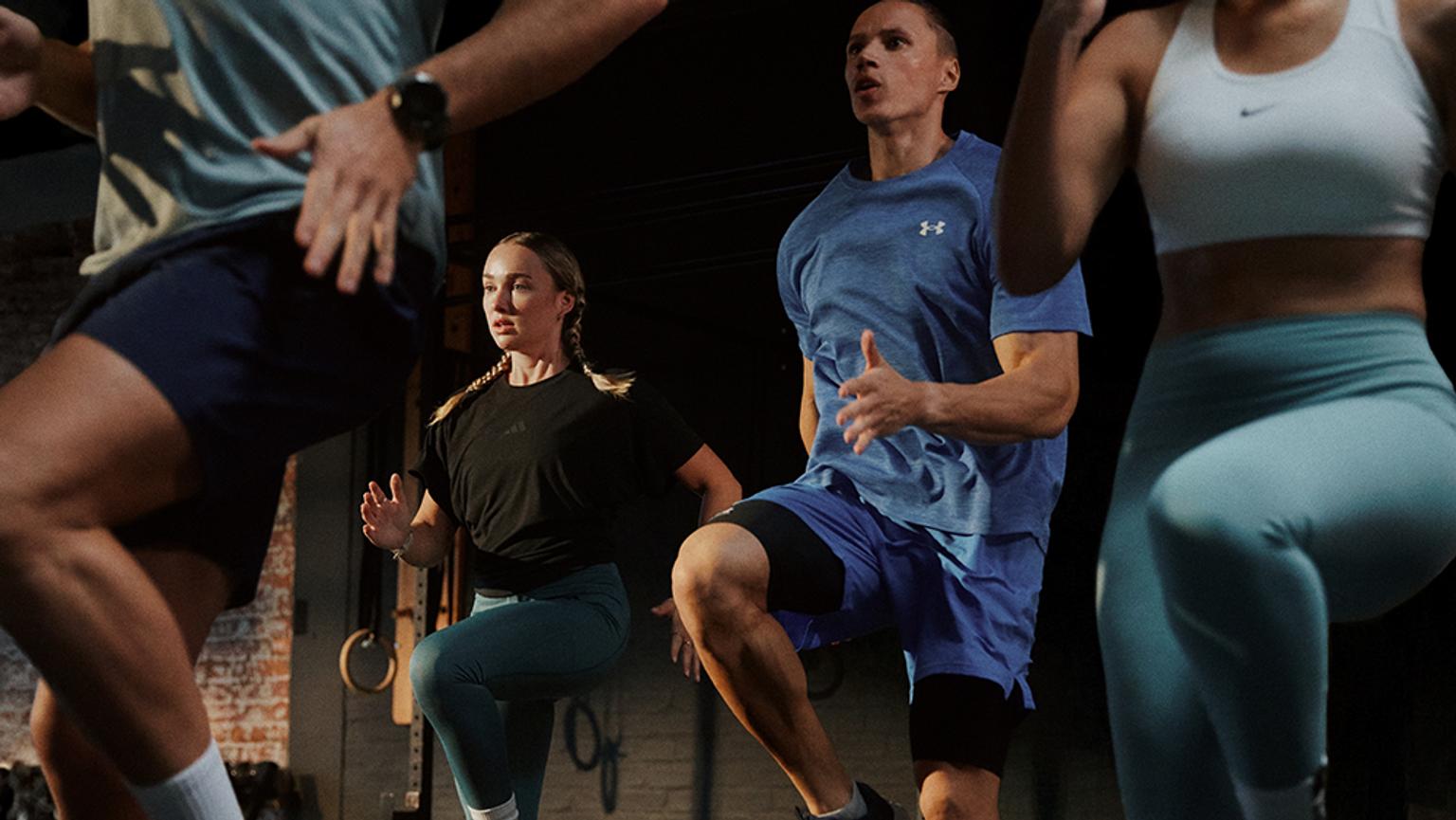 a group of people are doing squats in a gym .