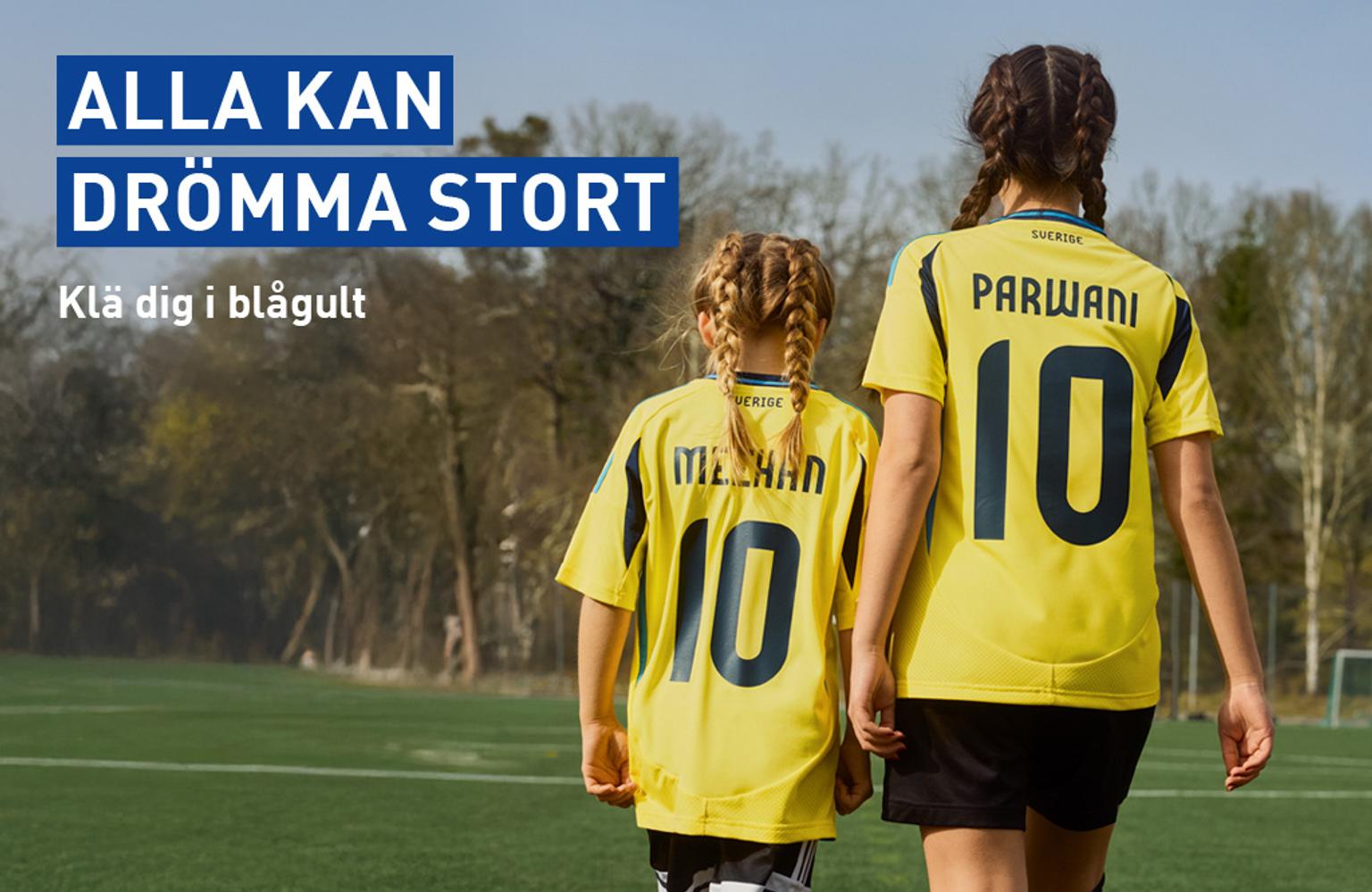 two girls in yellow jerseys are walking on a soccer field .