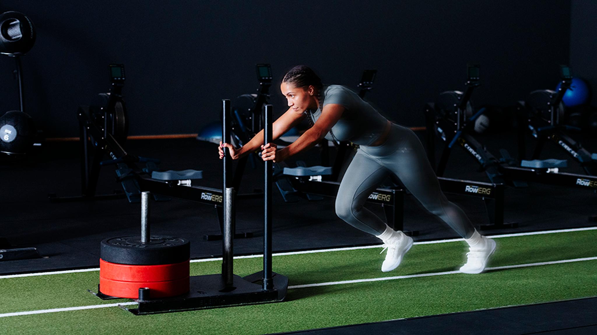 A group of people holding kettlebells during a workout in a gym.