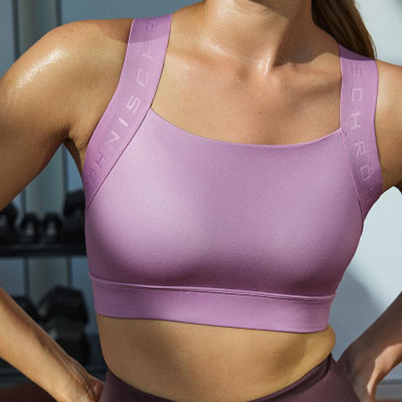 a woman is sweating in a purple sports bra .