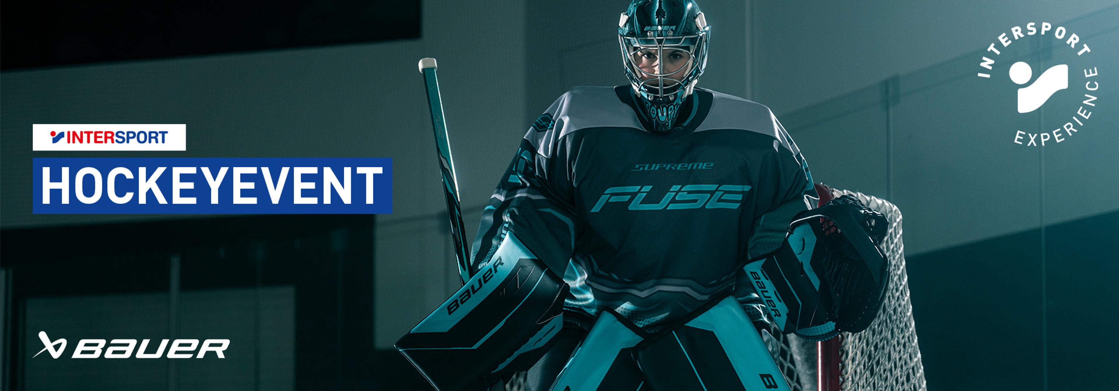 Hockey goalie in gear with "HOCKEYEVENT," "INTERSPORT," "Bauer," and "INTERSPORT EXPERIENCE" logos.