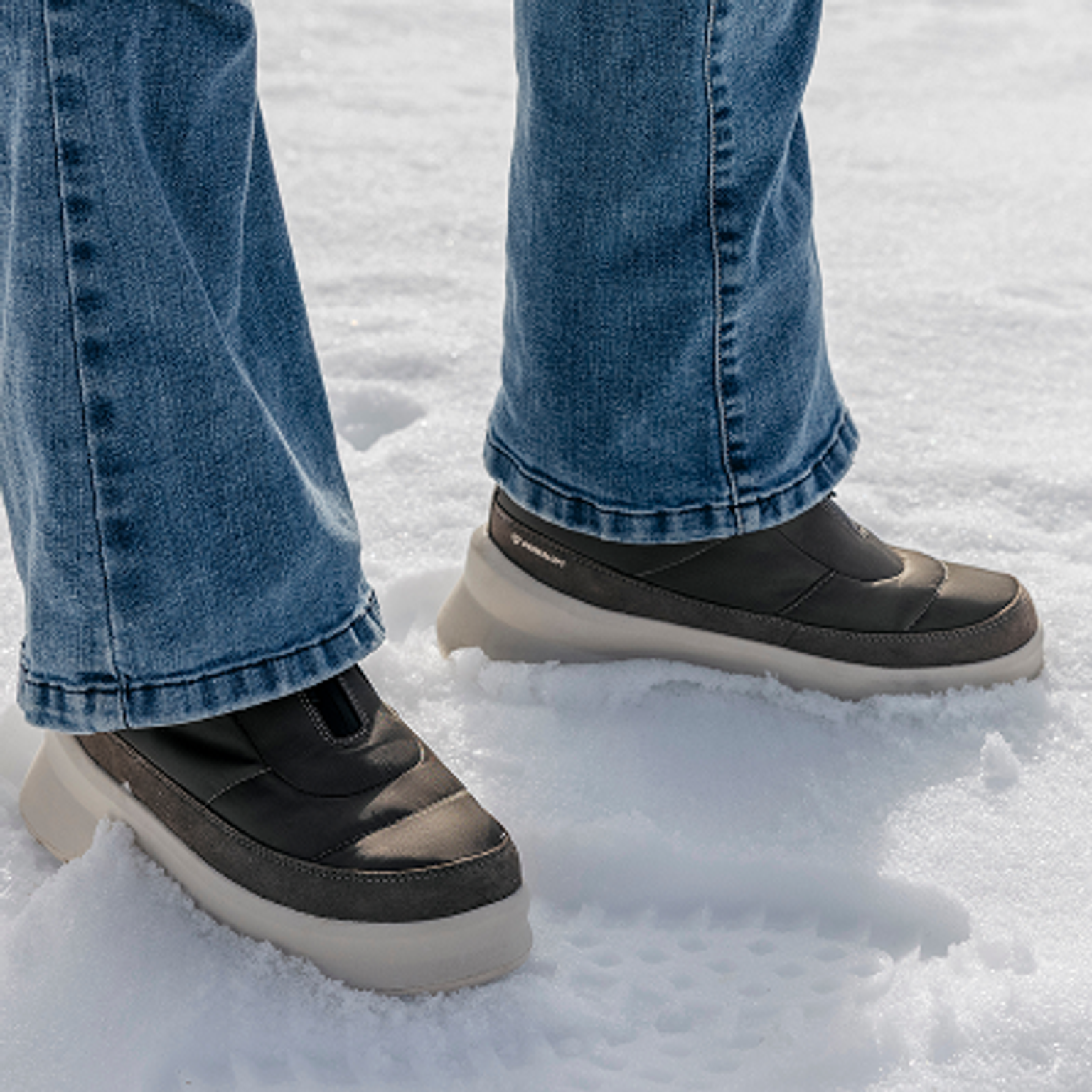 a person wearing a pair of skechers boots in the snow