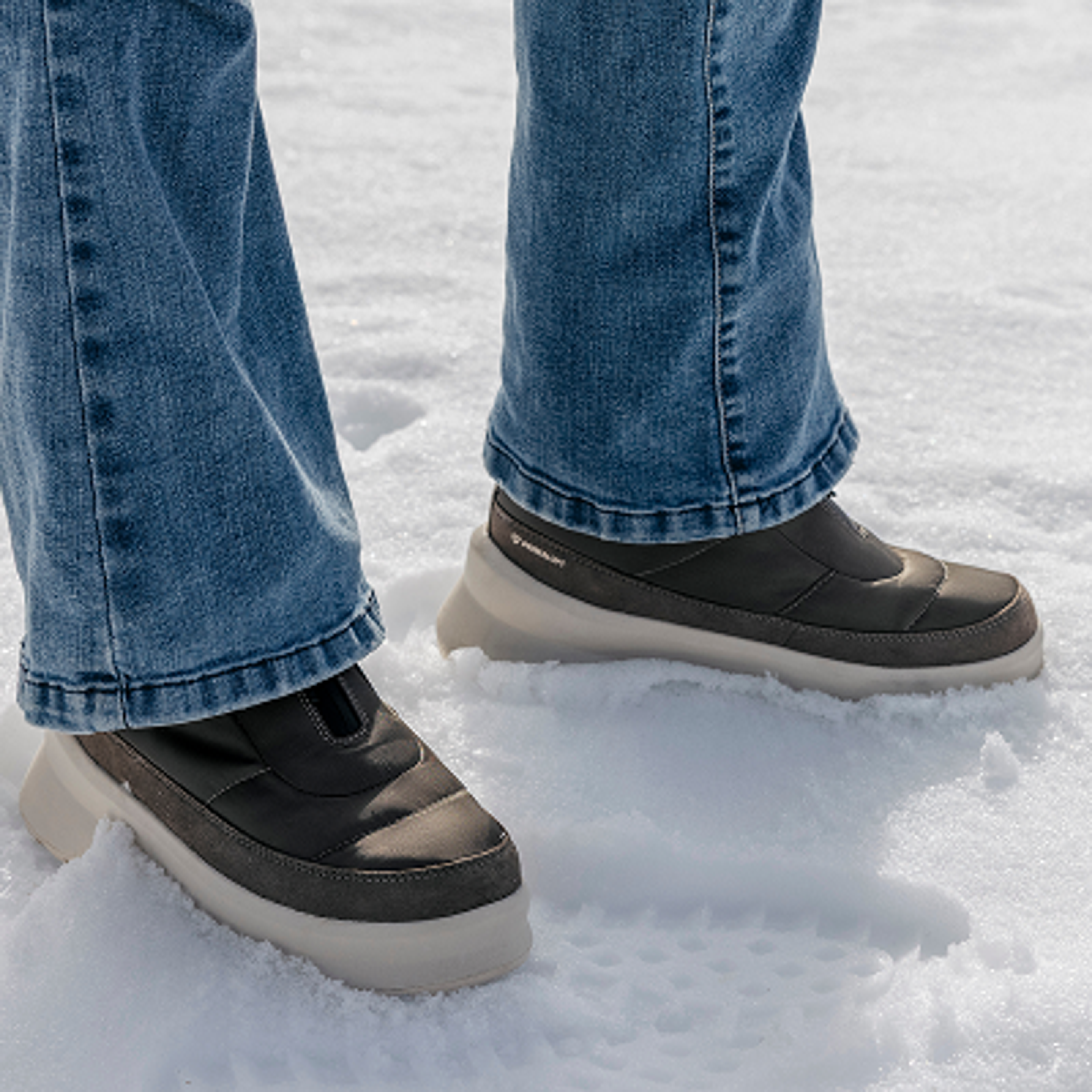a person wearing a pair of skechers boots in the snow