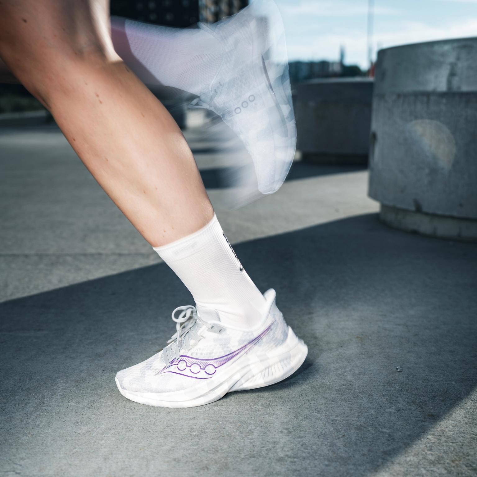 a person wearing a pair of saucony running shoes