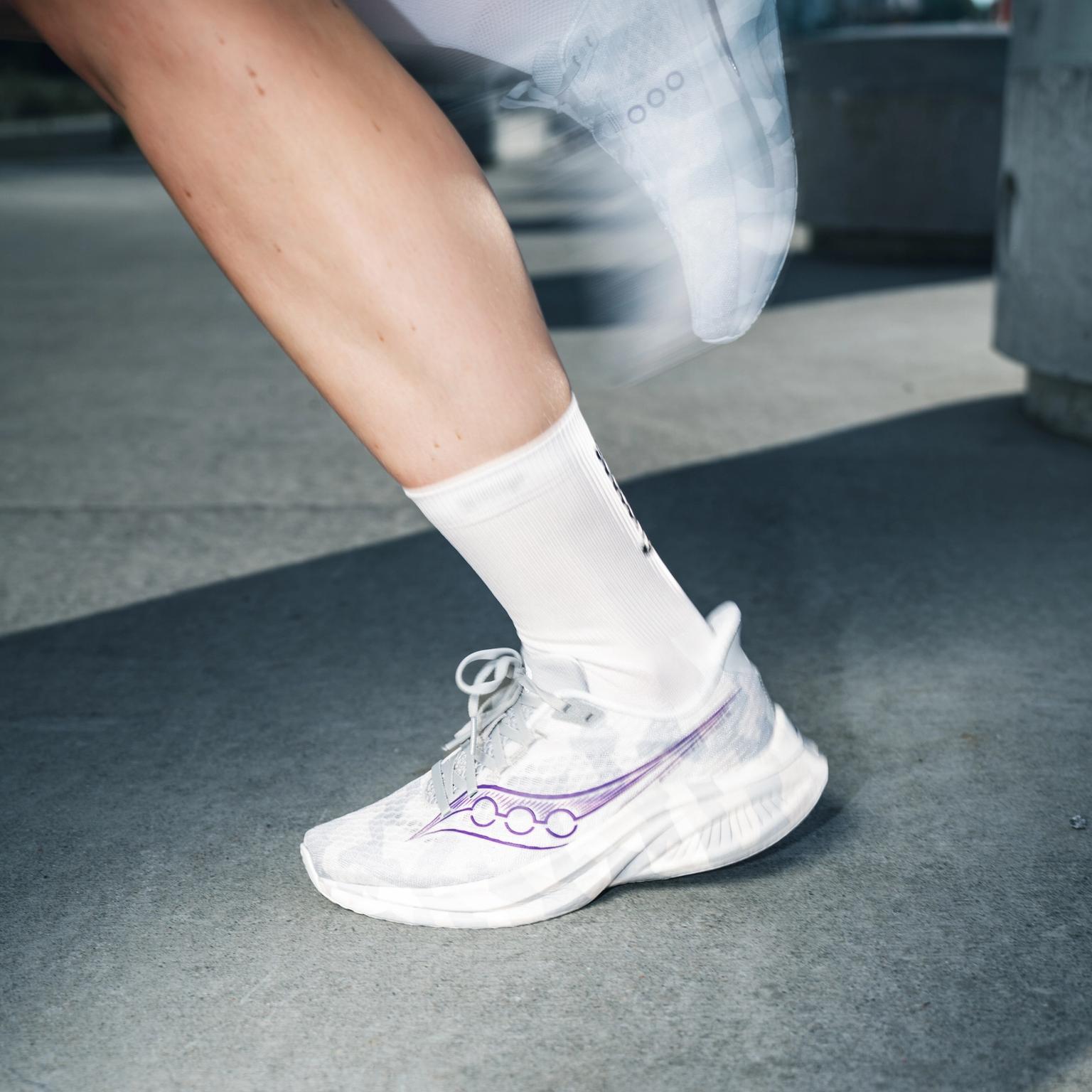 a person wearing a pair of saucony running shoes