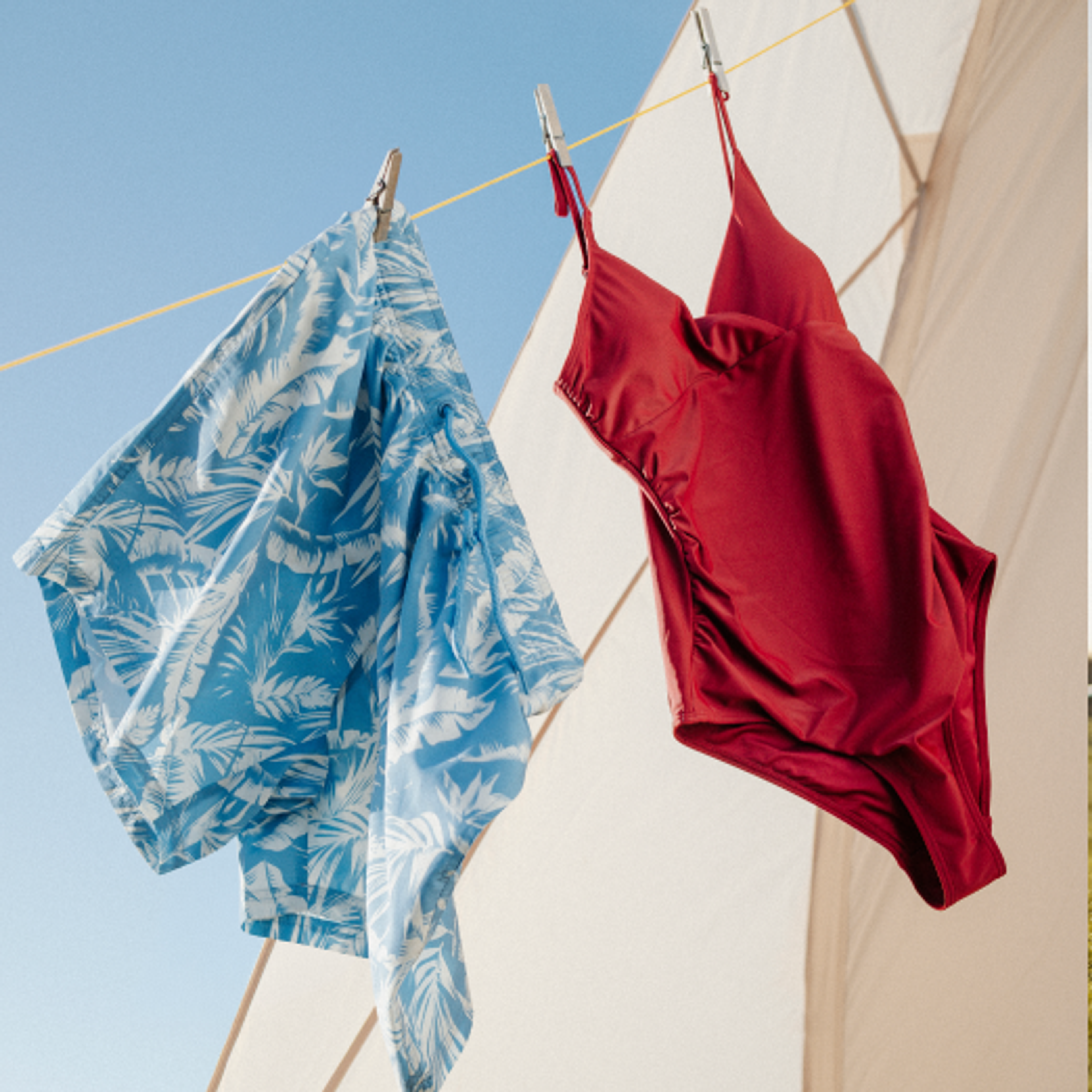 Swimwear drying on a line and a couple camping by a fire pit.