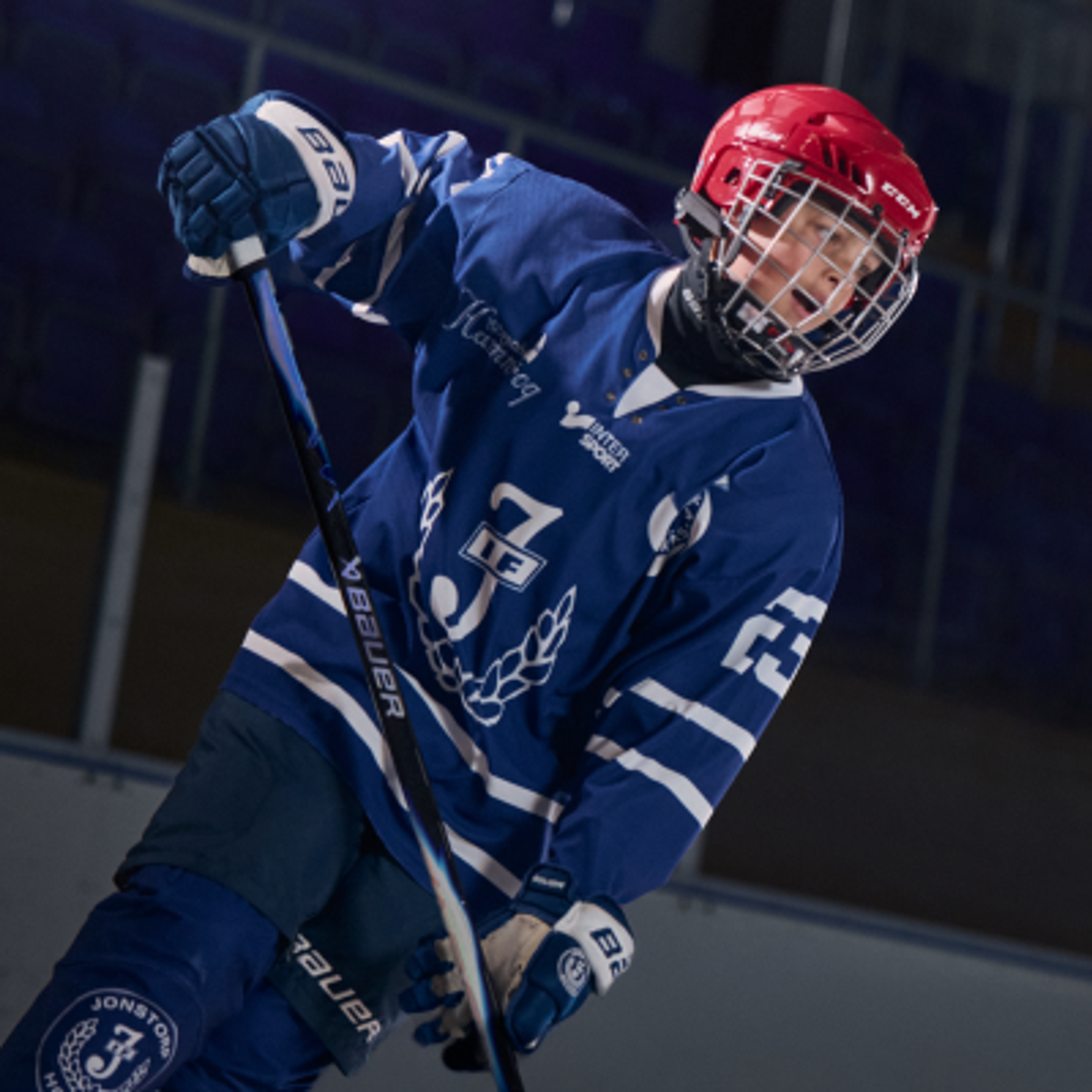 two young boys are playing ice hockey on a rink .