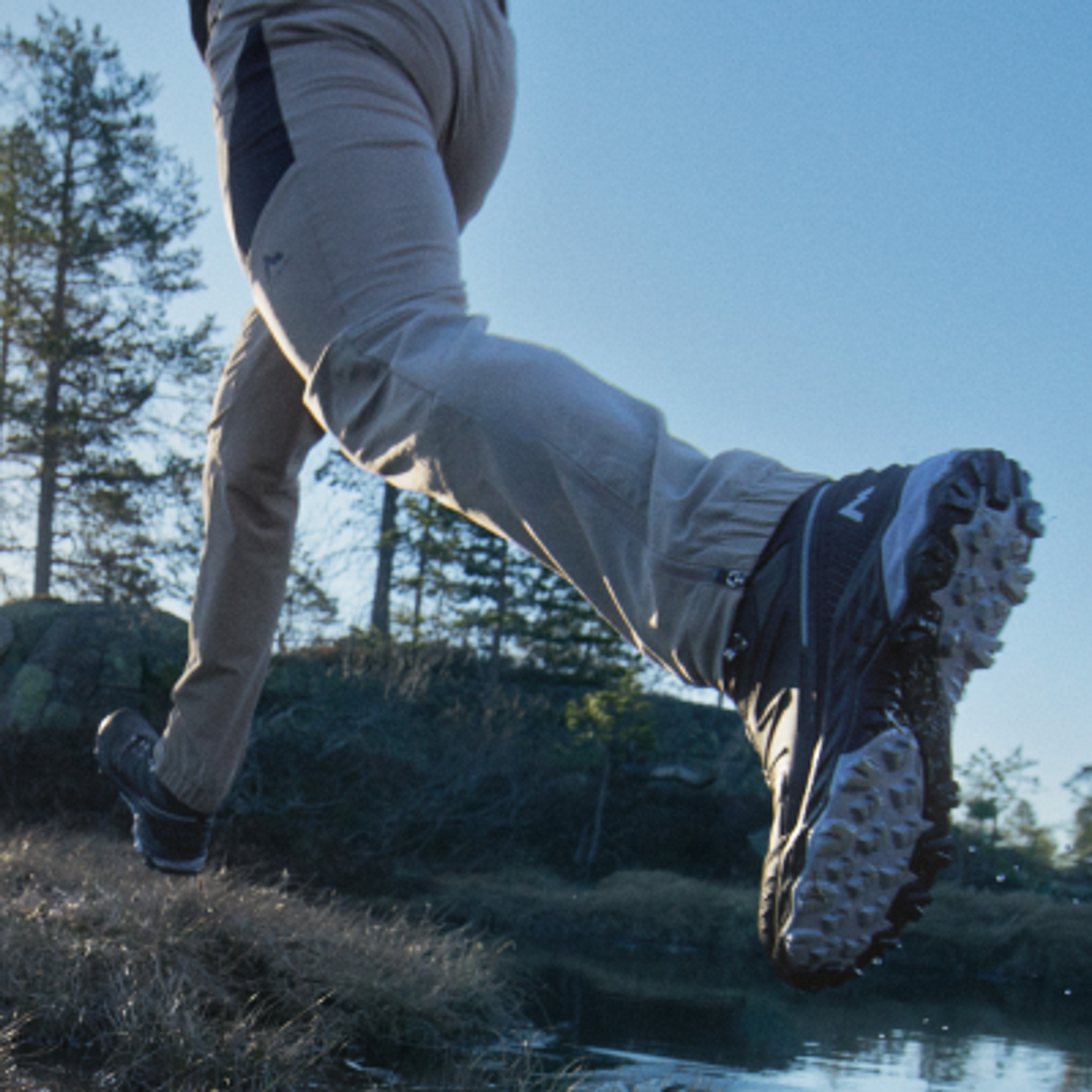 a person wearing a pair of adidas terrex shoes is walking through a puddle of water .