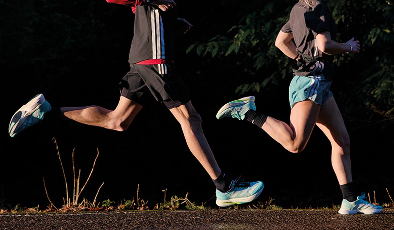 a man and a woman are running on a road .
