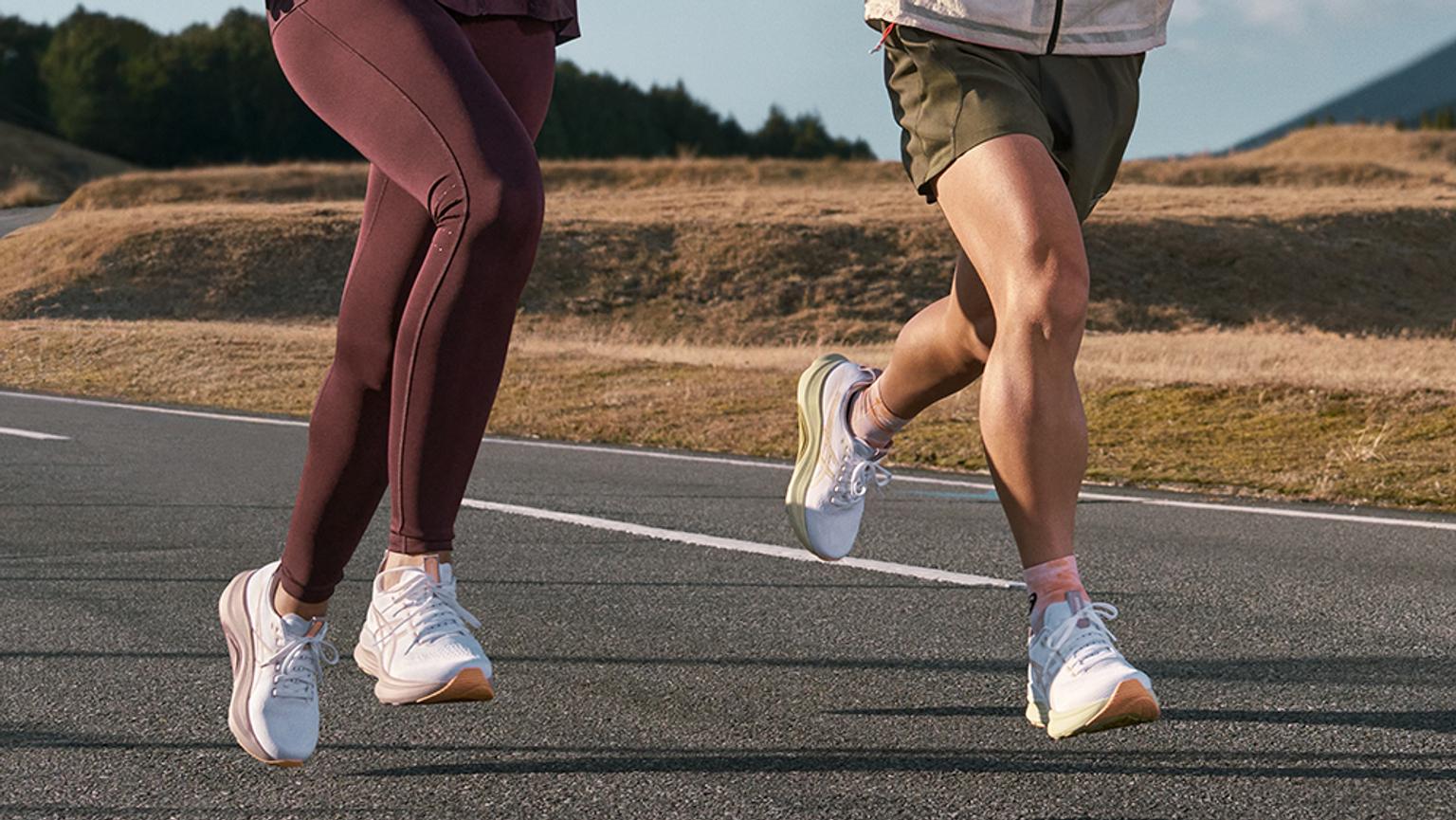 a man and a woman are running down a road .